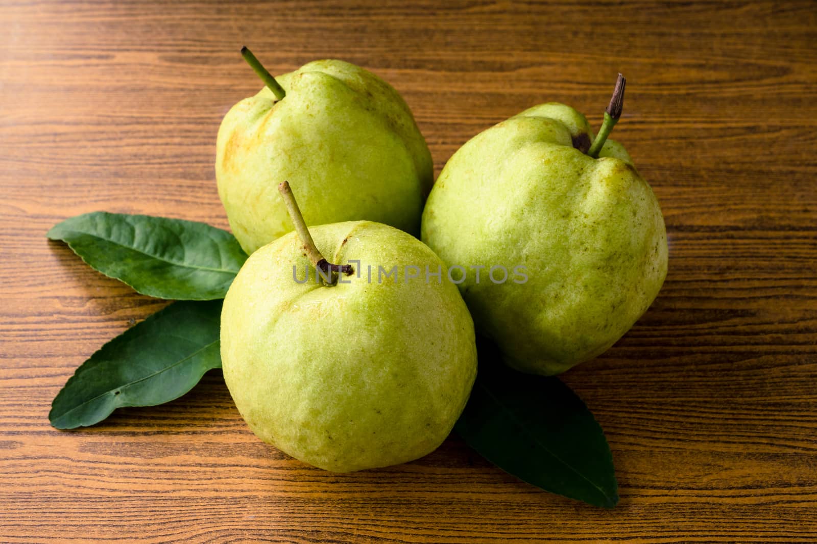 Fresh guava fruit on wooden table background.