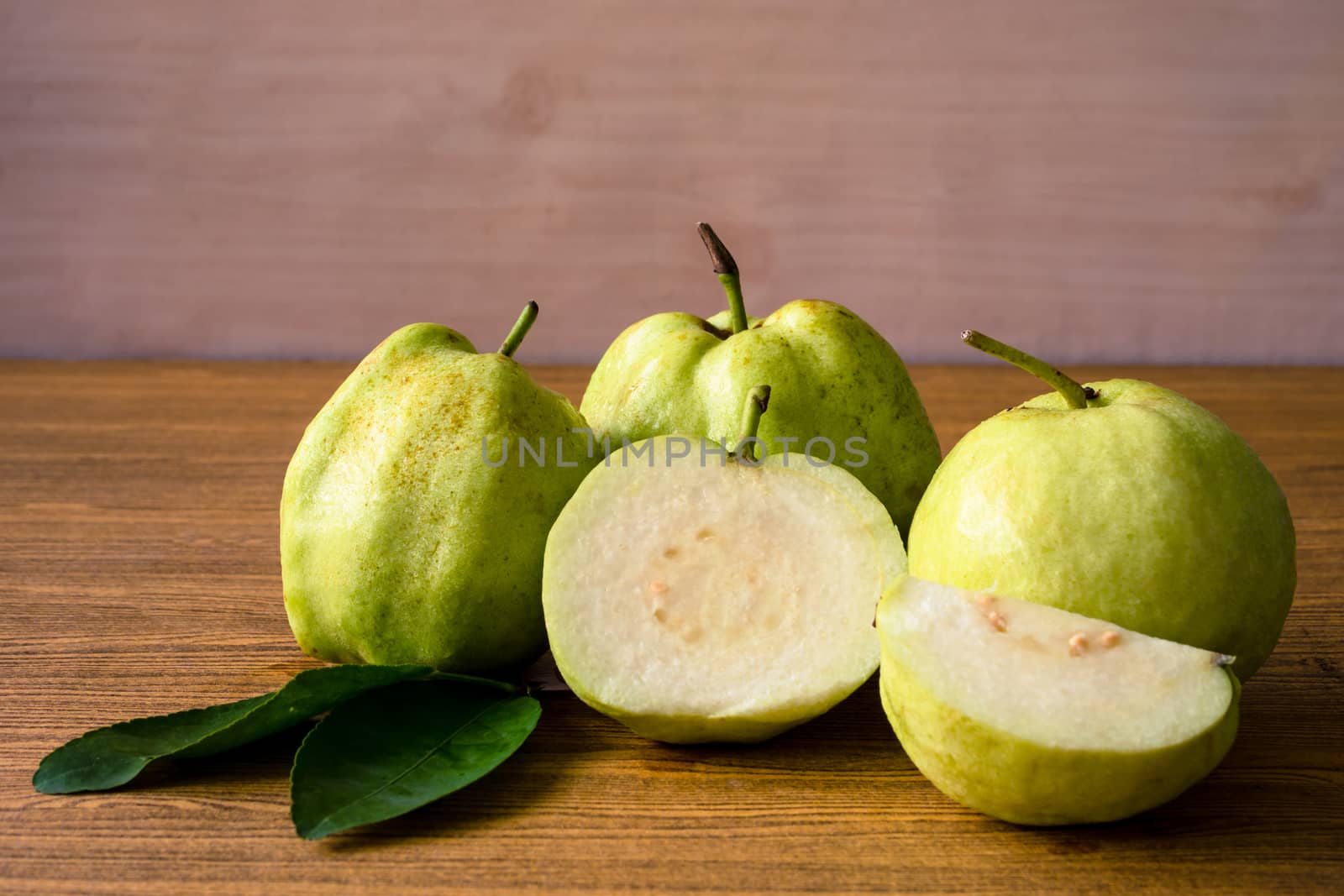 Fresh guava fruit on wooden table background.