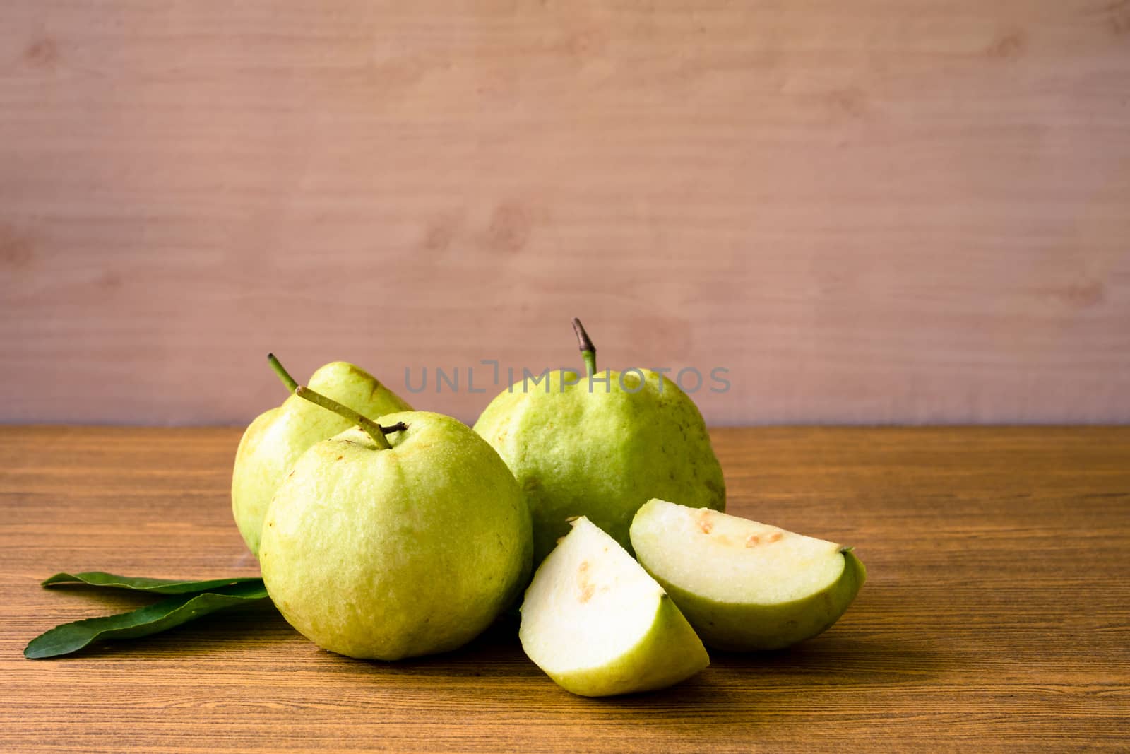 Fresh guava fruit on wooden table background.