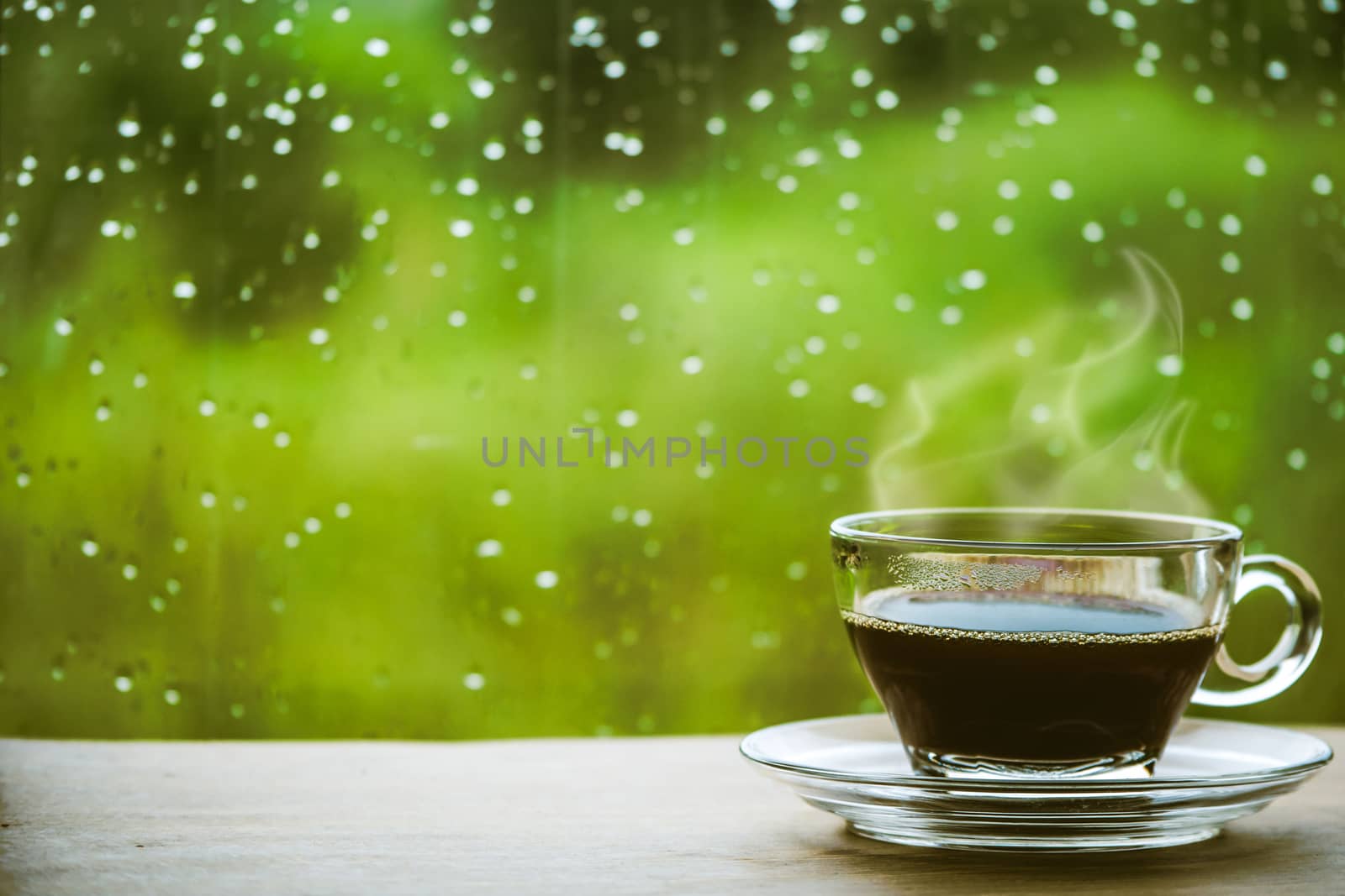 Cup of coffee on the table inside the window, coffee break in the morning with rainy day, relaxing and refreshing concepts.