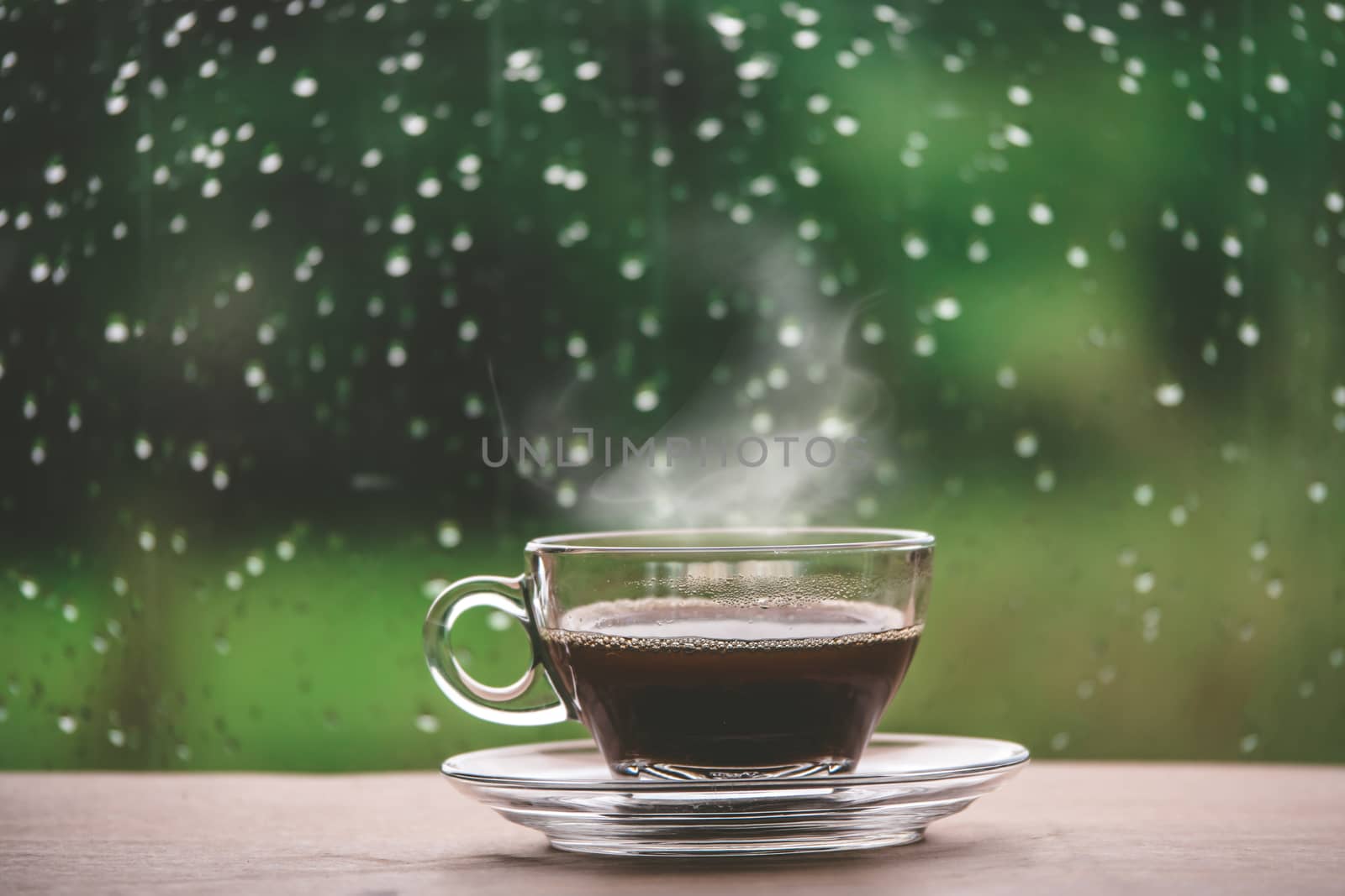Cup of coffee on the table inside the window, coffee break in the morning with rainy day, relaxing and refreshing concepts.