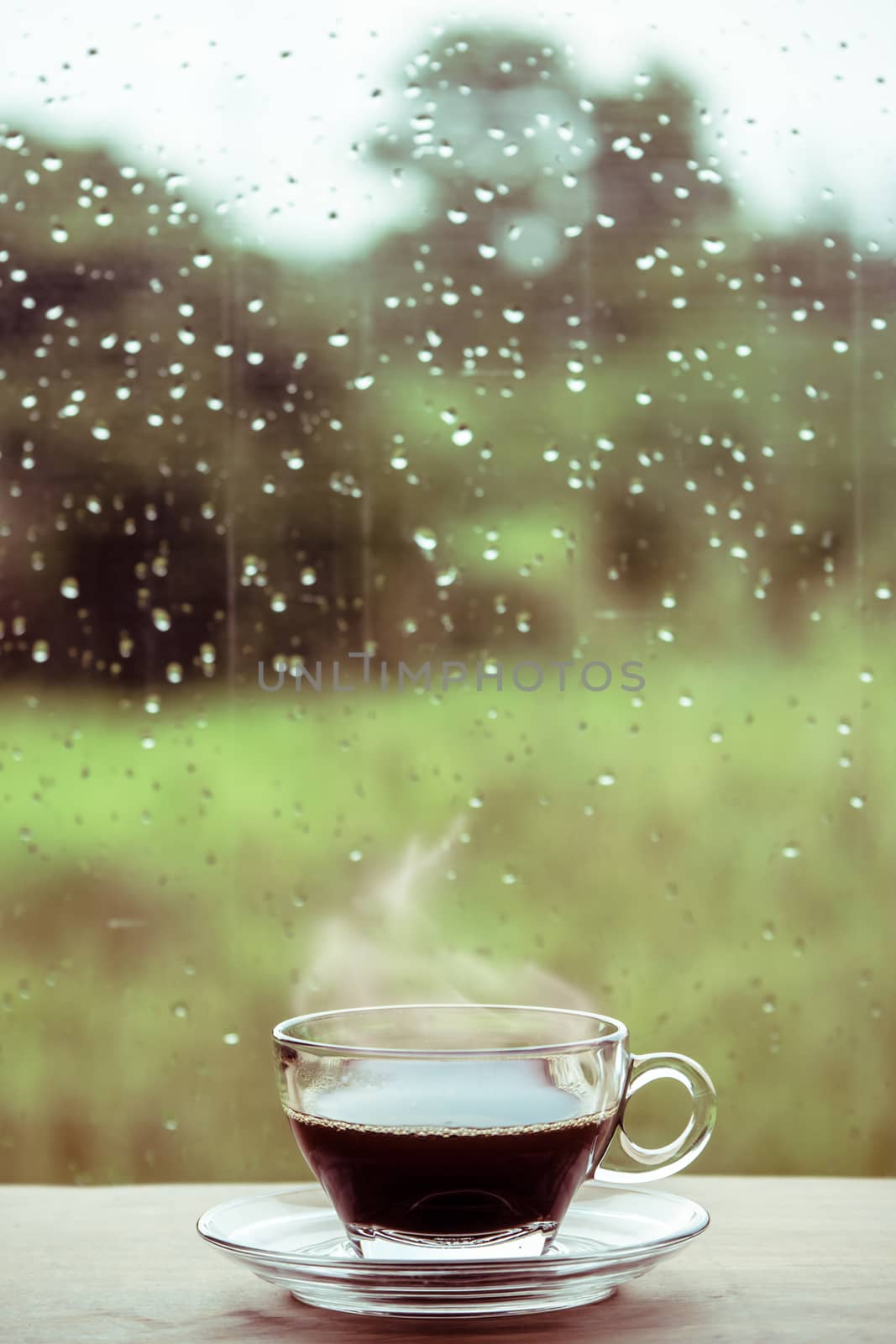 Cup of coffee on the table inside the window, coffee break in the morning with rainy day, relaxing and refreshing concepts.