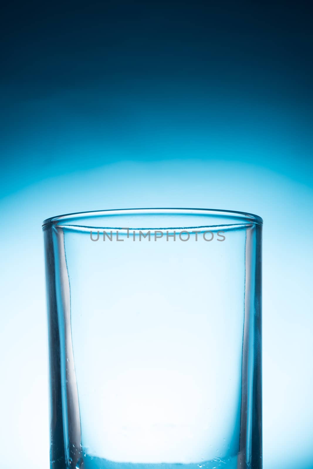 Empty glass on a blue background. by ronnarong