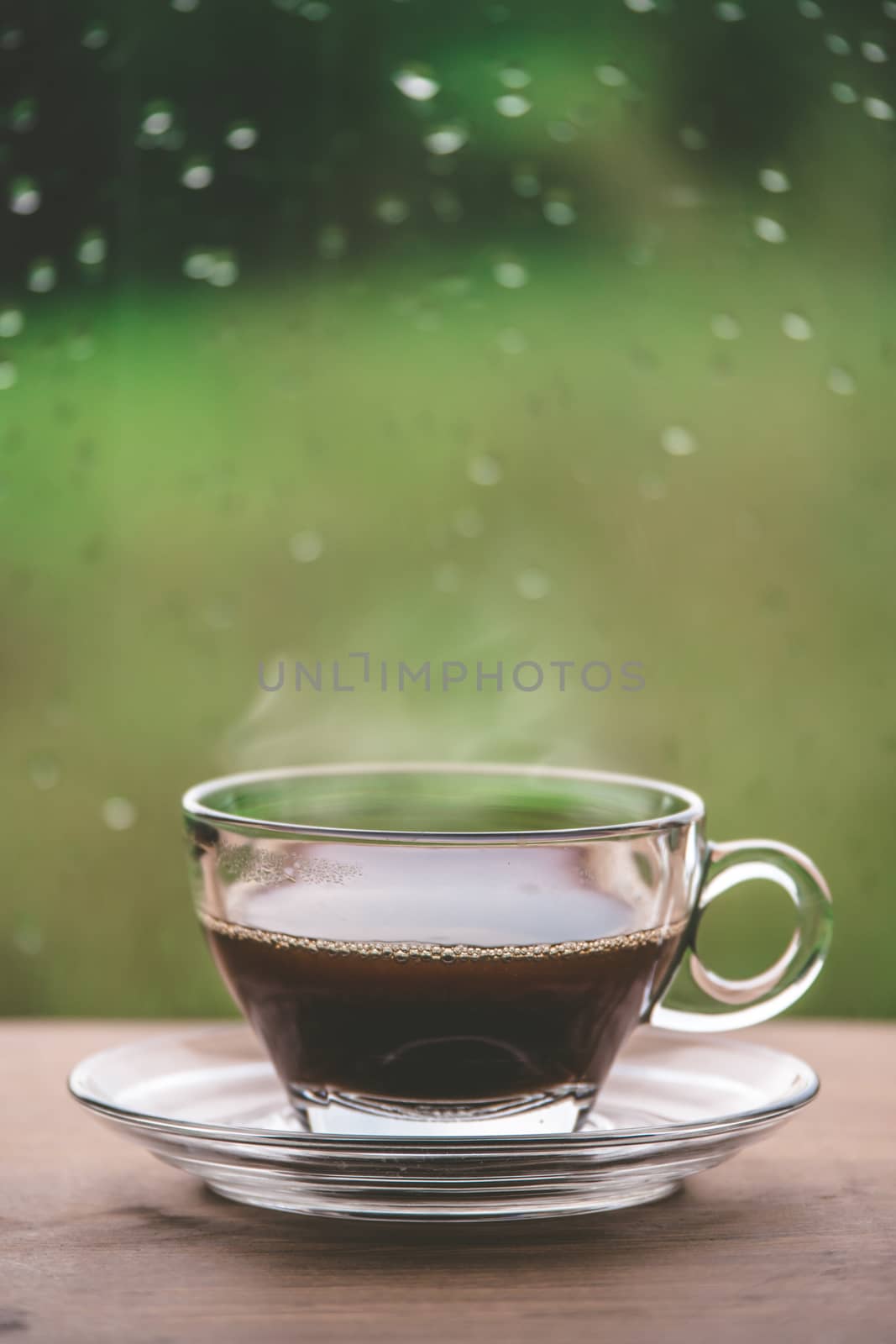Cup of coffee on the table inside the window, coffee break in the morning with rainy day, relaxing and refreshing concepts.