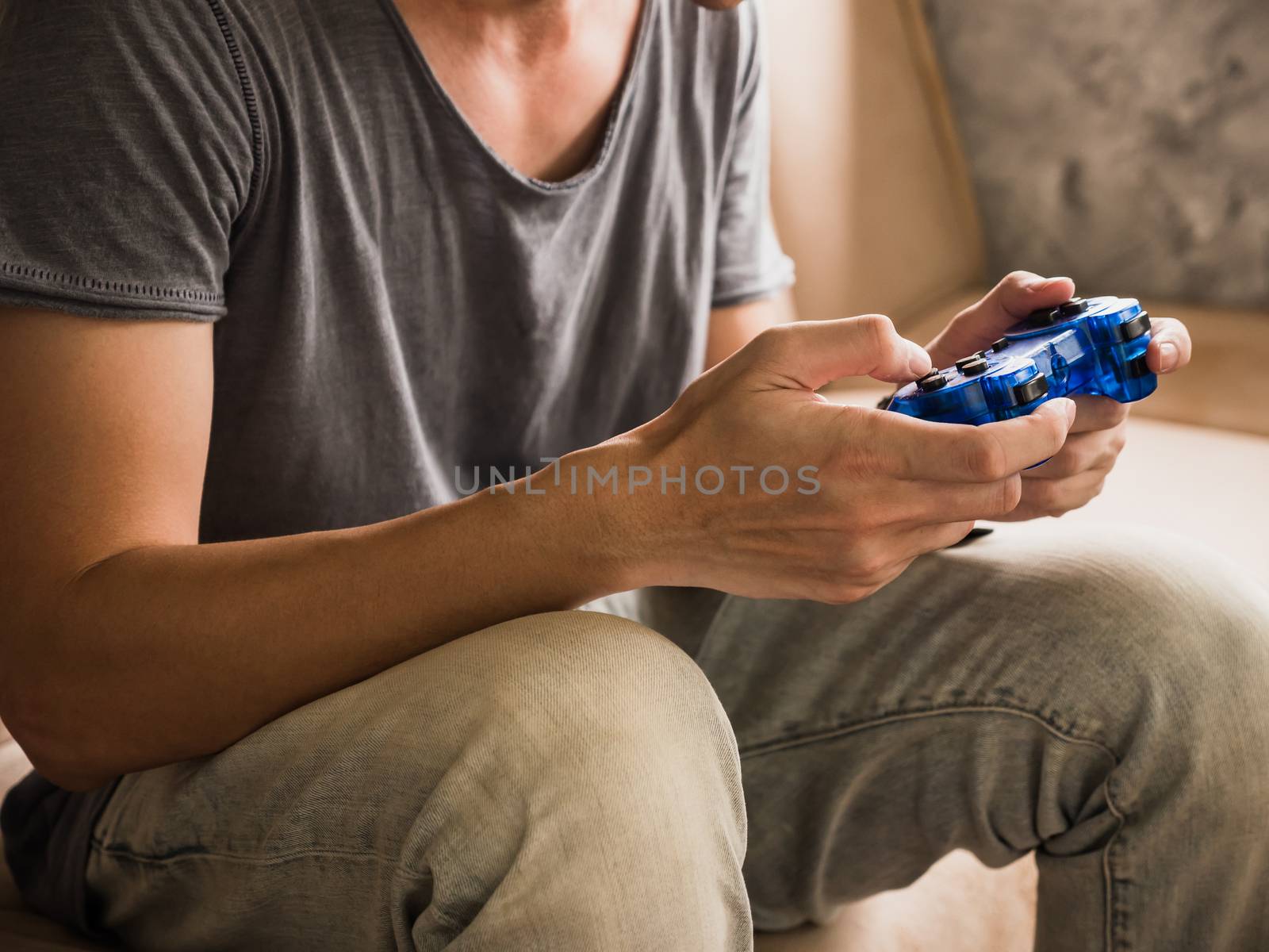 Close up of a young gamer playing the video game with a joystick.