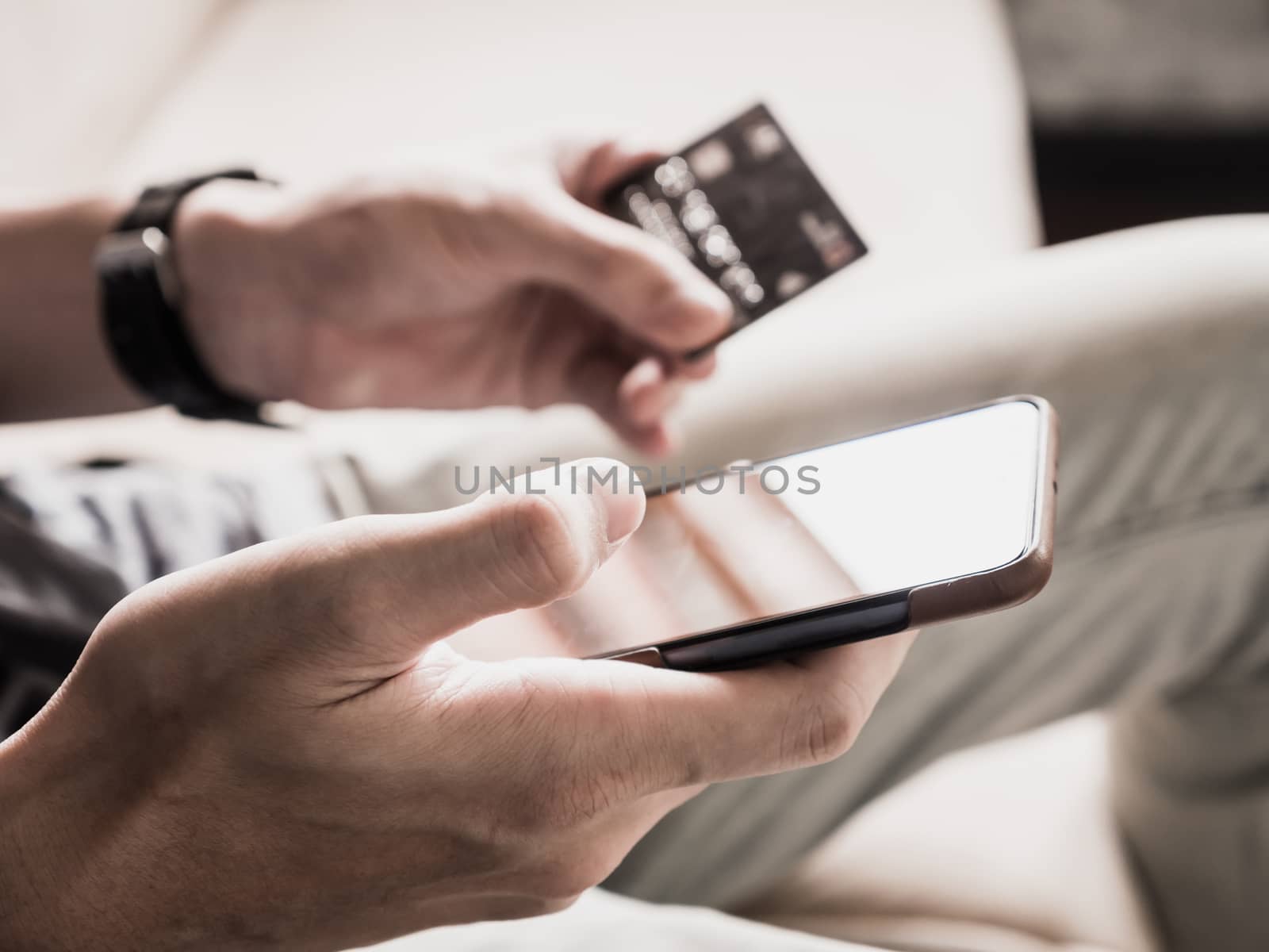 Close up of male hands using smartphone and holding credit card. Online shopping concept. selective focus