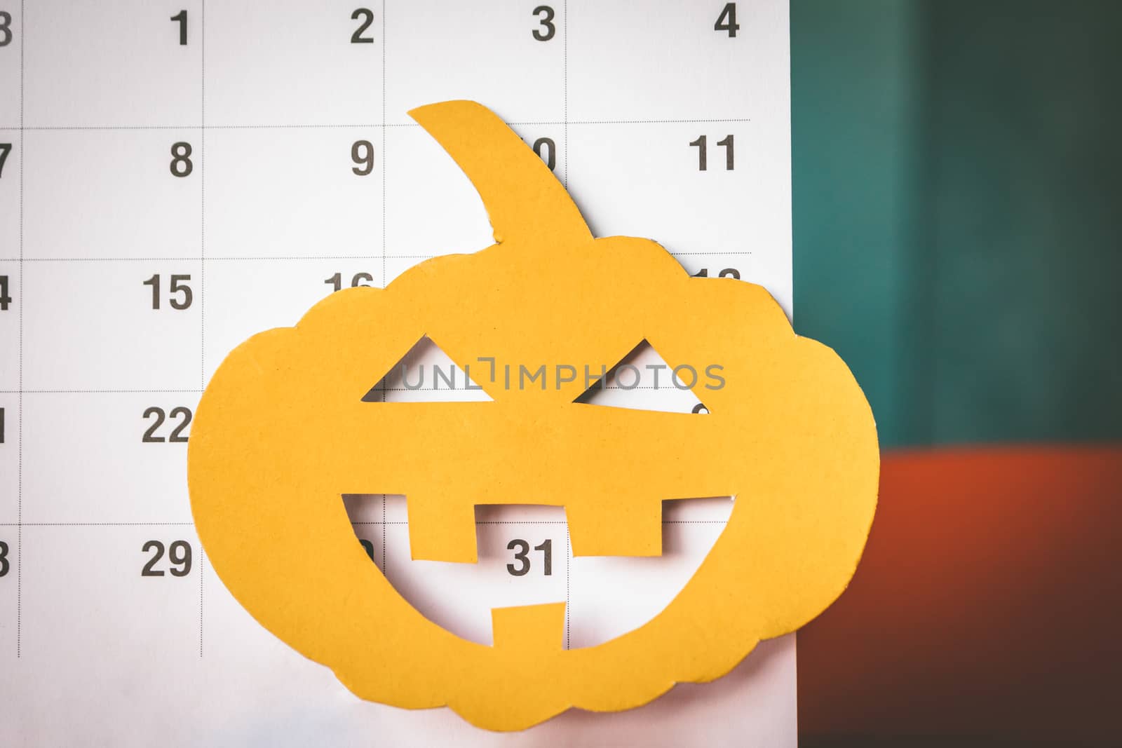 Halloween holiday concept, Pumpkin cut paper with calendar.