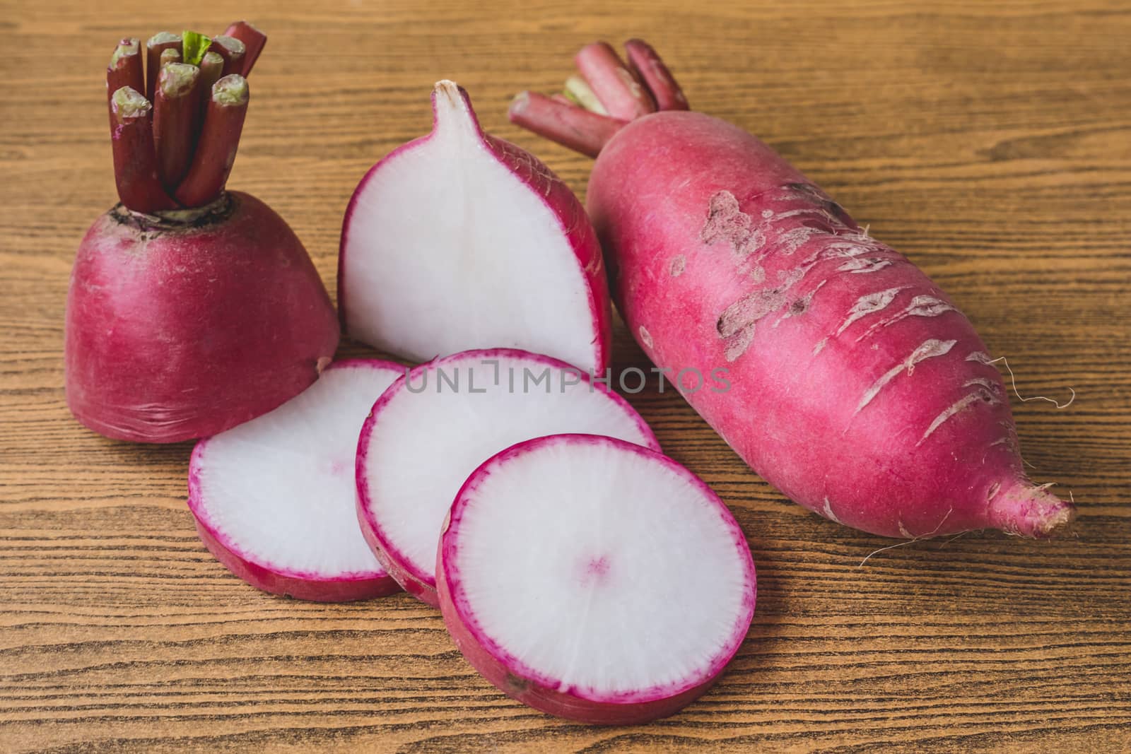 Fresh Pink Radishes on wooden table background.
