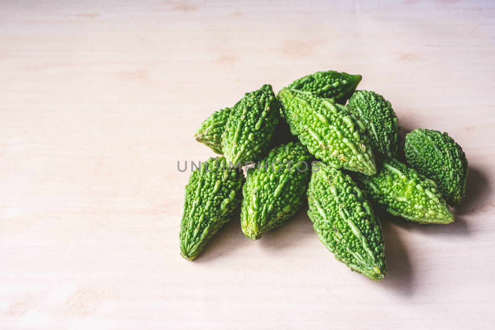 Bitter melon or bitter gourd on wooden background. free space for text