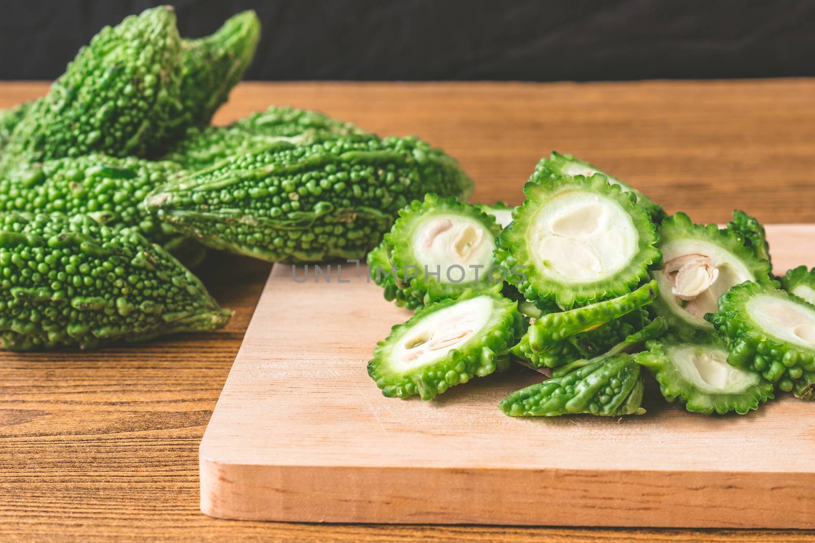 Bitter melon or bitter gourd on wooden tray.