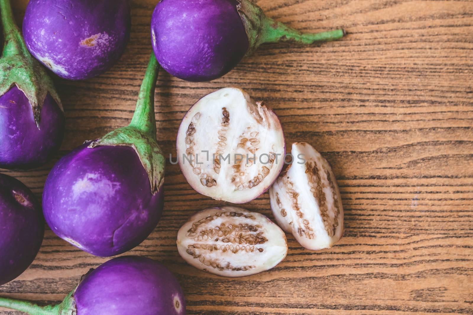 Fresh Purple eggplants on wooden table.