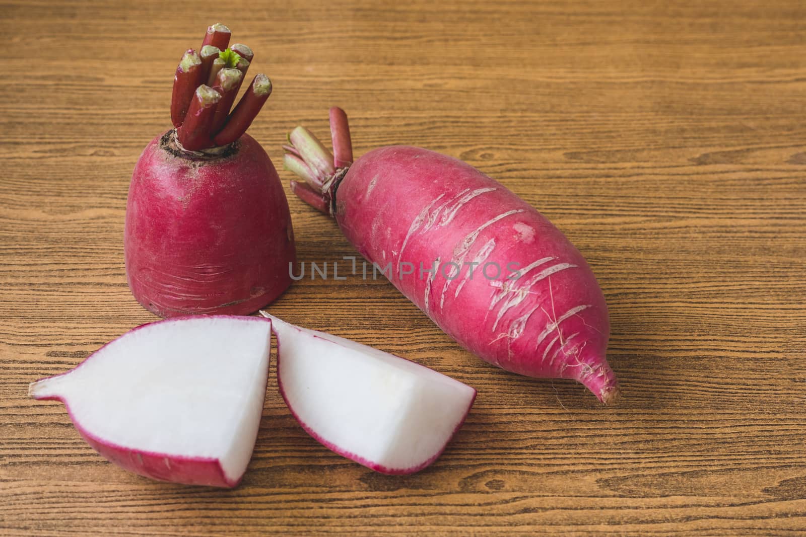 Fresh Pink Radishes on wooden table background.