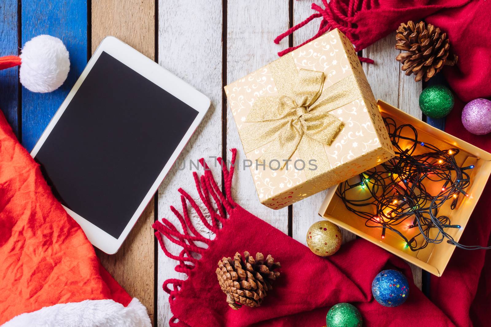 Top view of Tablet and christmas decoration on wooden table. by ronnarong