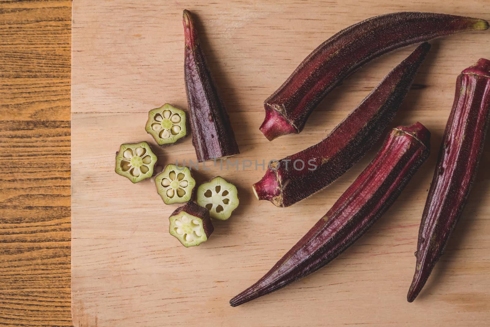 Fresh Red okra on wooden background.