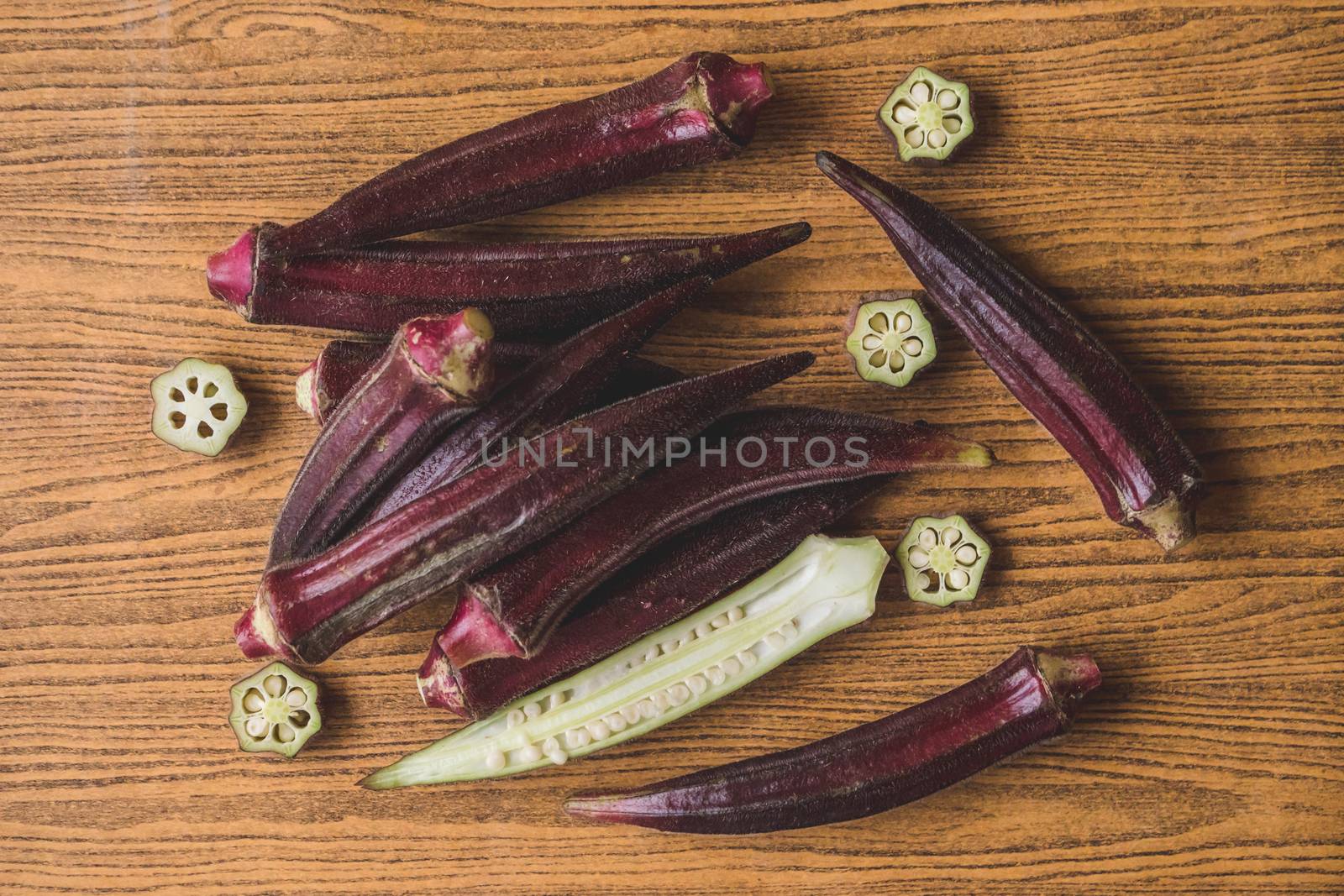 Fresh Red okra on wooden background. by ronnarong