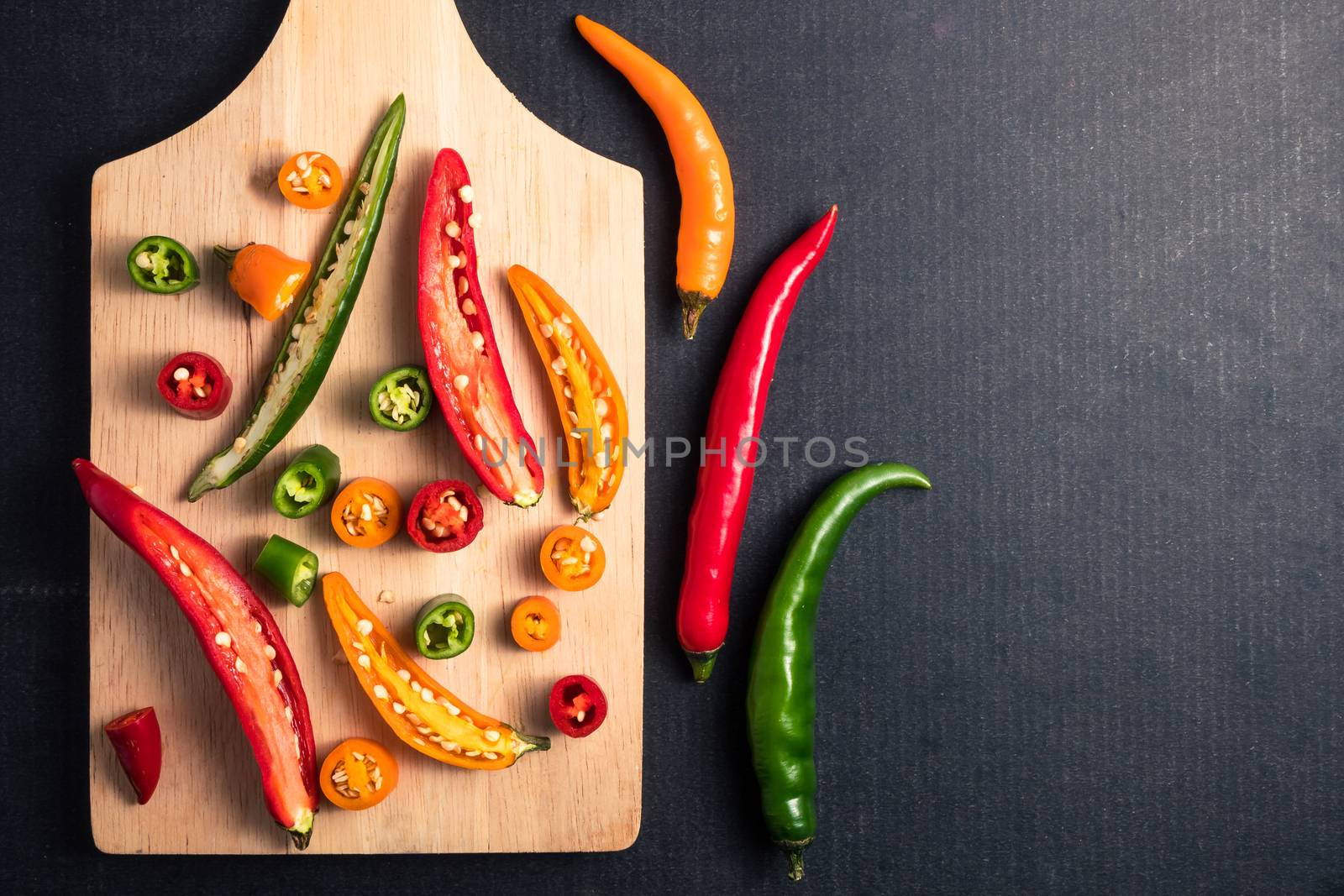 Colorful mix of chili pappers on black background. Free space for text by ronnarong