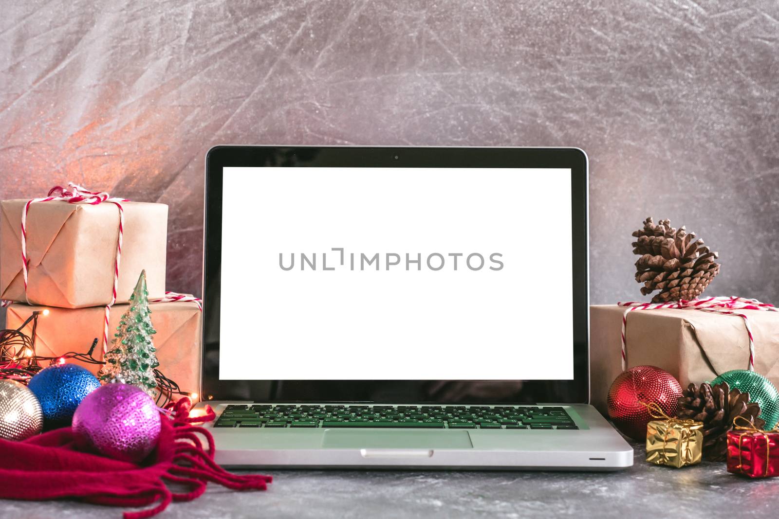 Laptop with white screen, gift boxes and christmas decoration on the table. by ronnarong