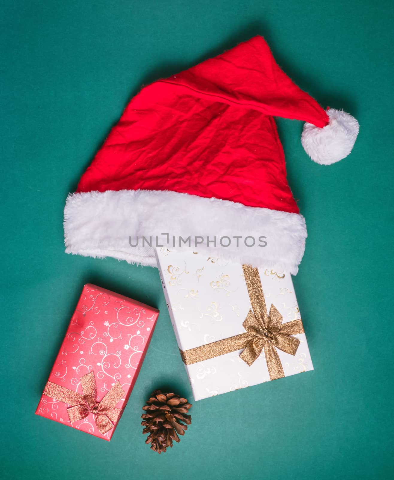 Top view of empty gift boxes with santa hat on green background.