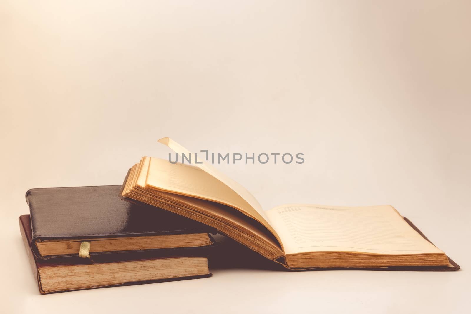 A stack of old books with vintage background. by ronnarong