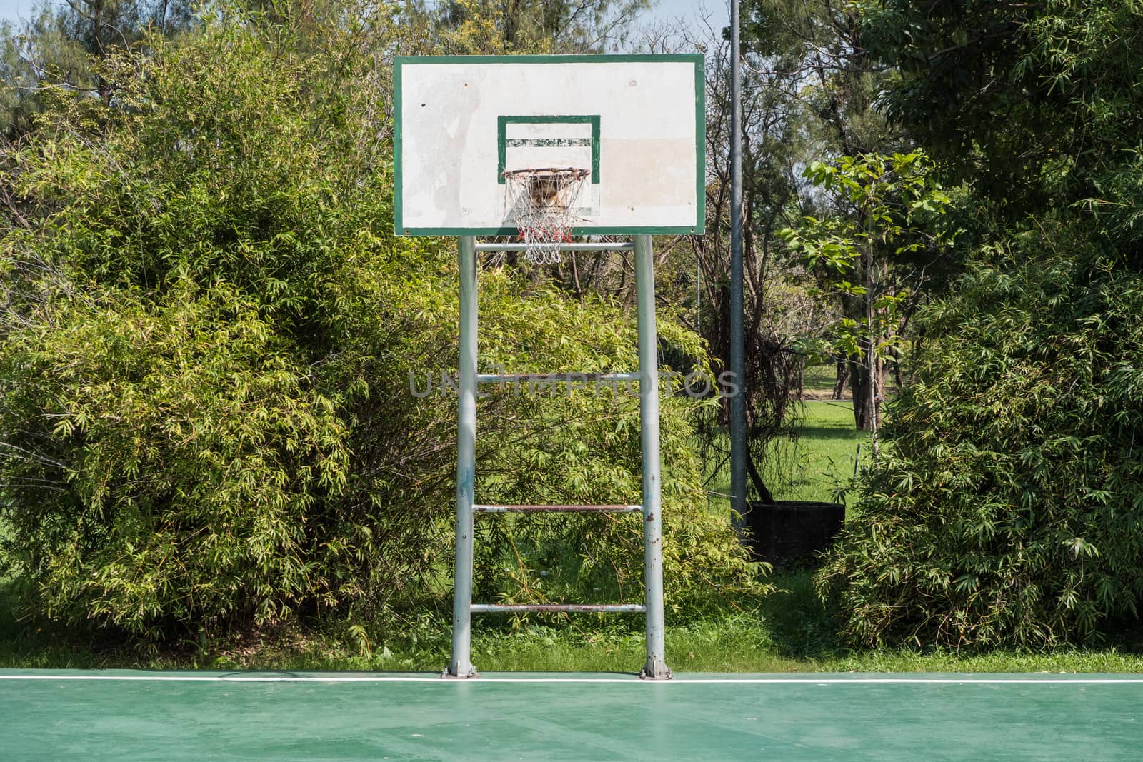 A backboard on basketball court in a park.