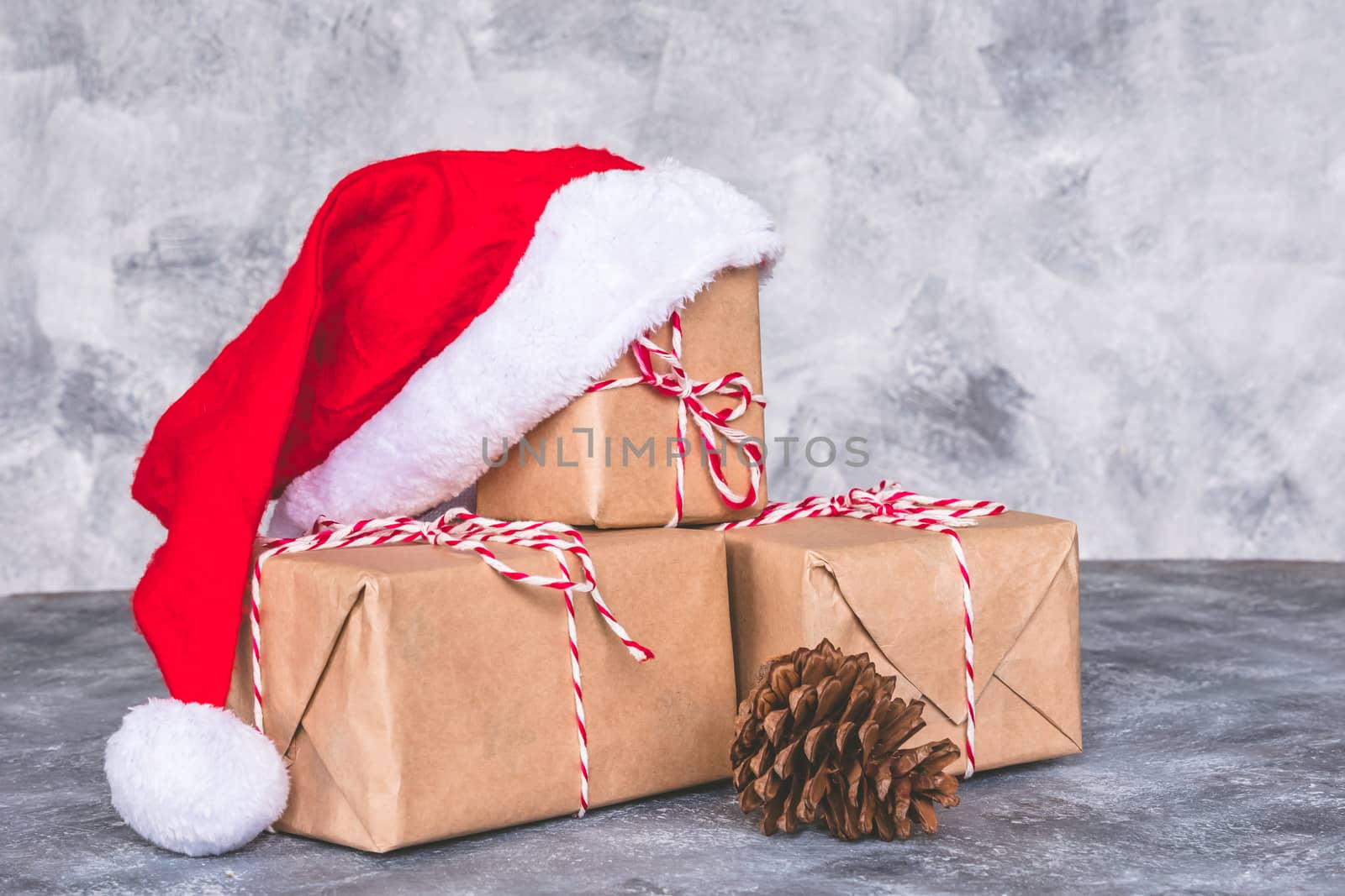 Top view of santa hat with gift box on gray grunge background. Free space for text by ronnarong