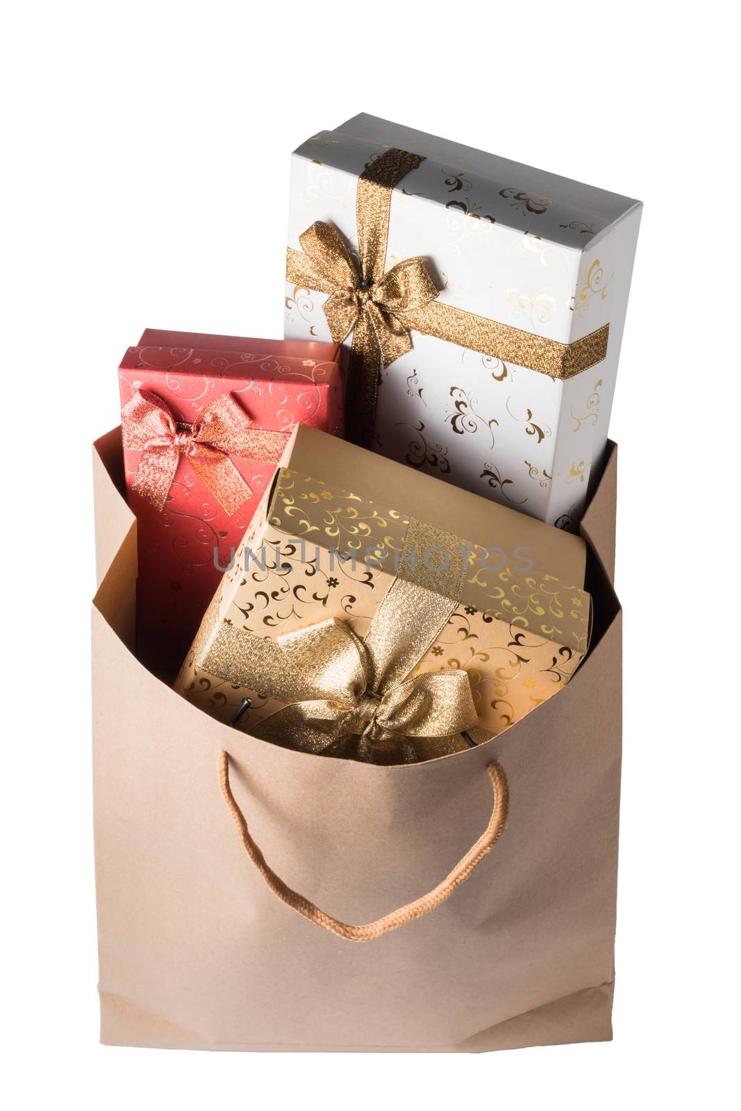 Gift boxes in brown paper bag on white background.