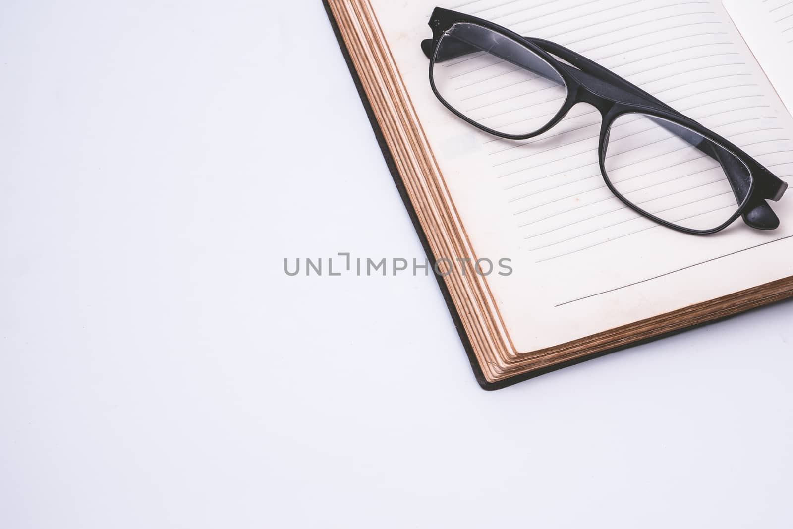 An open notebook with glasses on white background. Free space for text by ronnarong