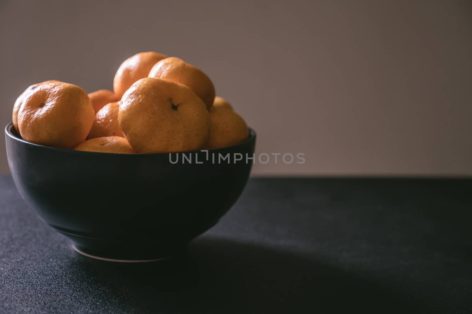 Fresh tangerines in bowl, Orange fruits on dark background.