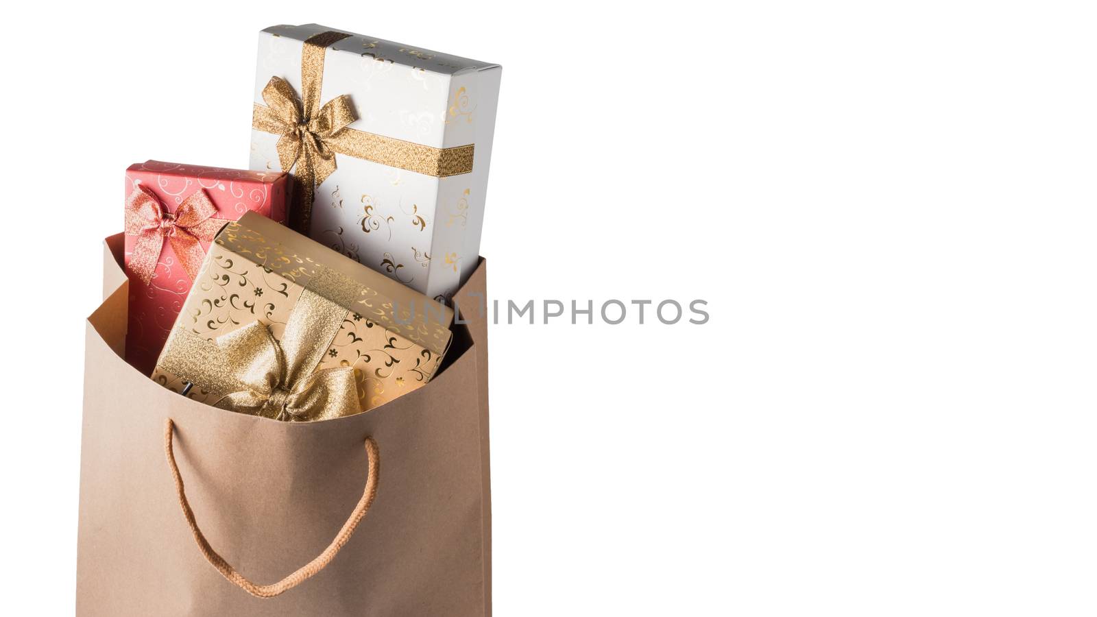 Gift boxes in brown paper bag on white background. Free space for text by ronnarong
