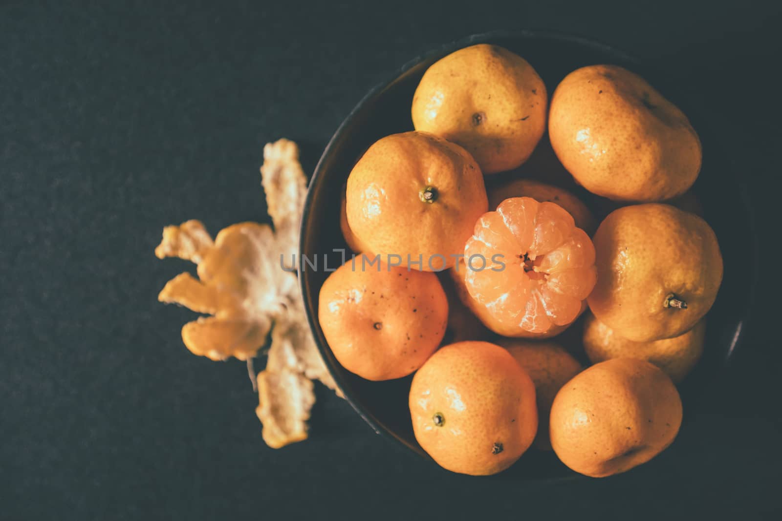 Fresh tangerines in bowl, Orange fruits on dark background.