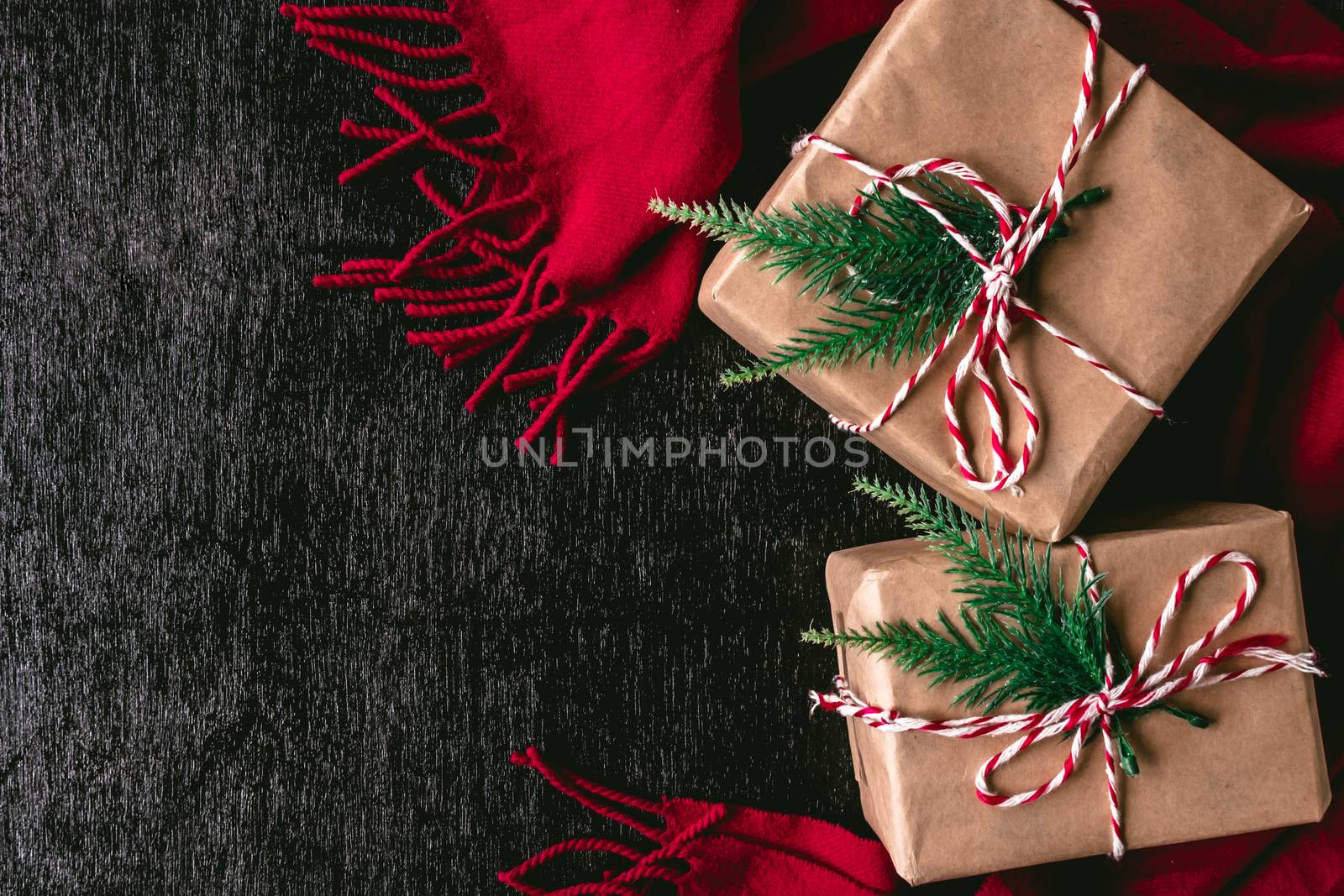 Top view of Gift packages wrapped in brown paper and red scarf on black background. Free space for text by ronnarong