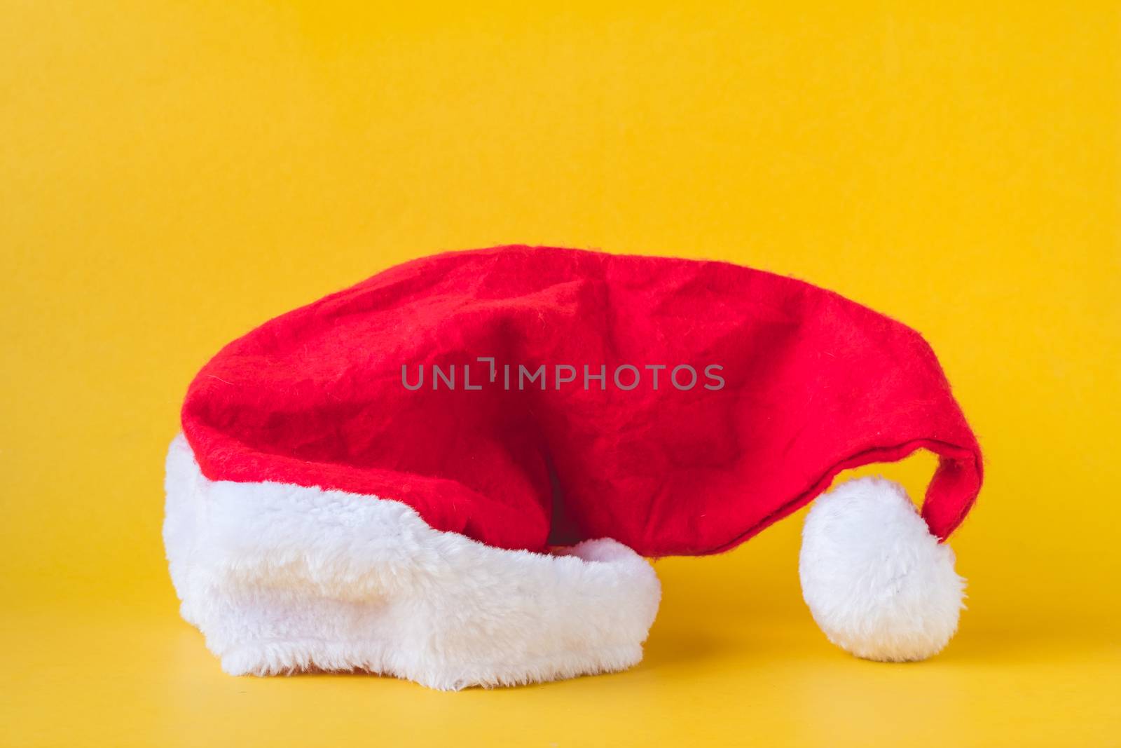 Santa Claus red hat on yellow background. Christmas concept