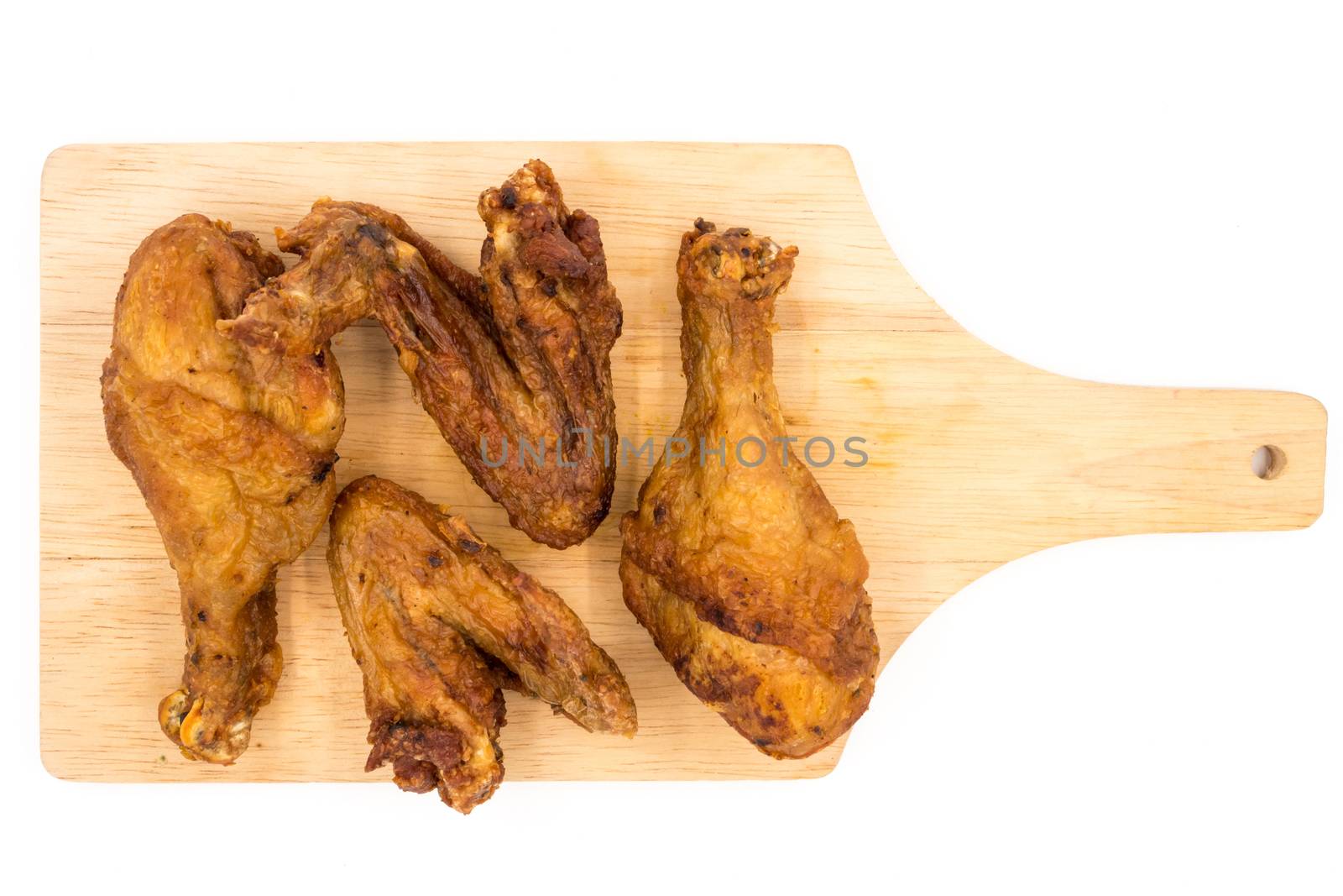 Fried chicken legs and wings on wooden tray over a white background.