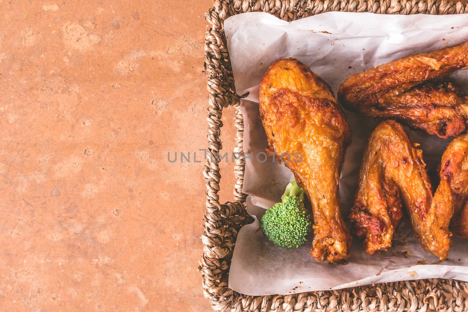 Top view of Fried chicken legs and wings in basket. Free space for text