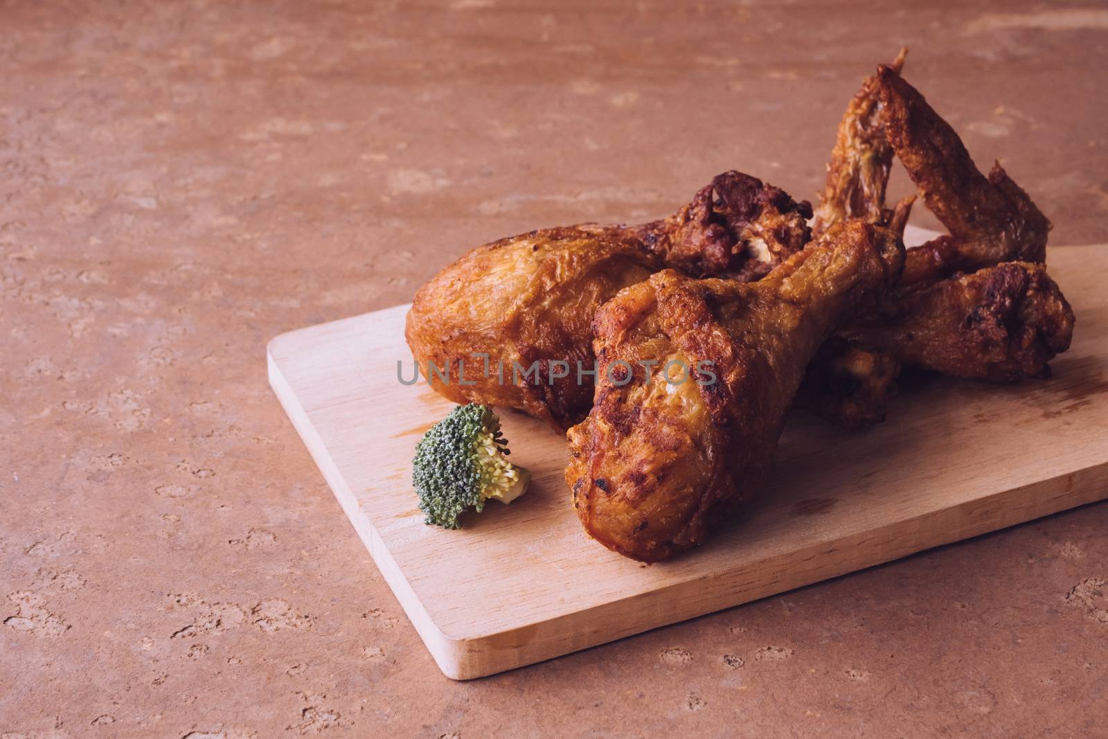 Fried chicken legs and wings on wooden tray. by ronnarong