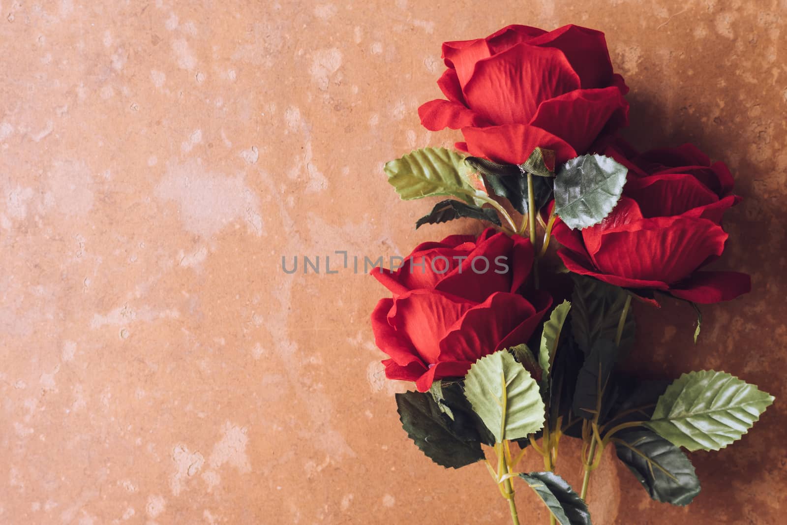 Bunch of Red roses on brown grunge board background. Free space  by ronnarong