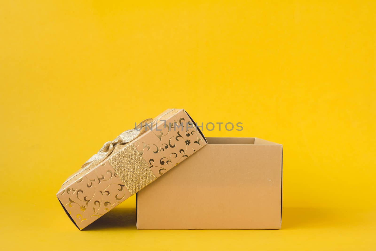 Open golden gift box on a yellow background.