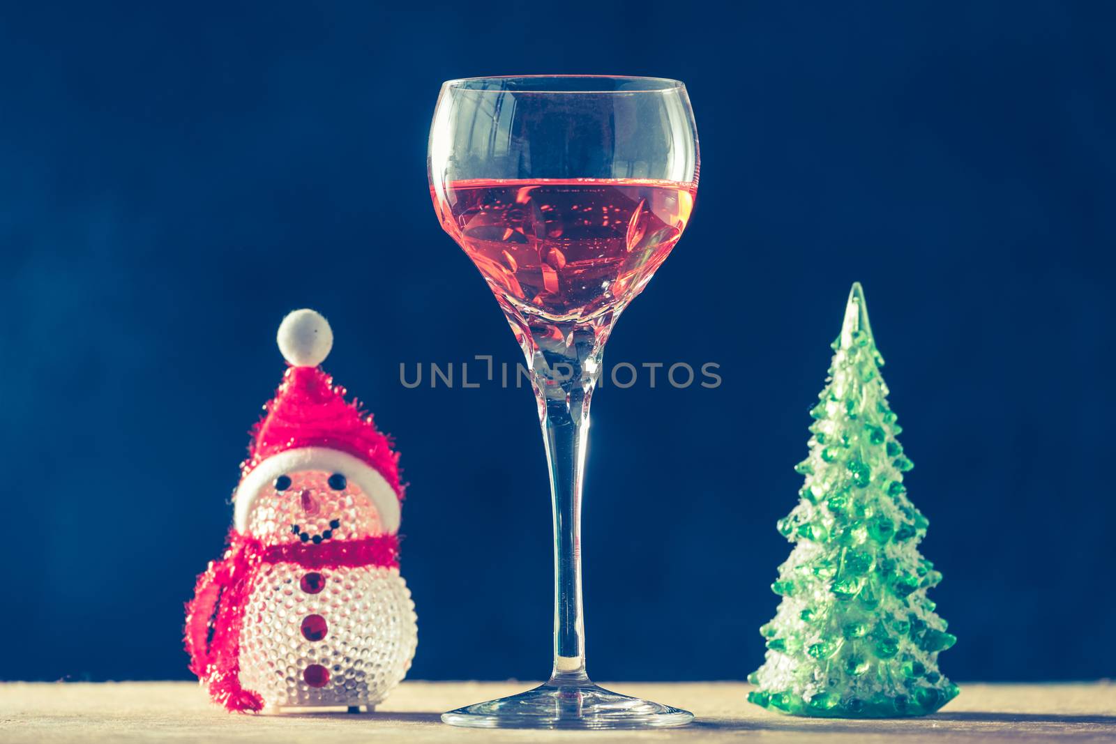 Glass of wine with Christmas decorations on the wooden table, black background,  vintage tone