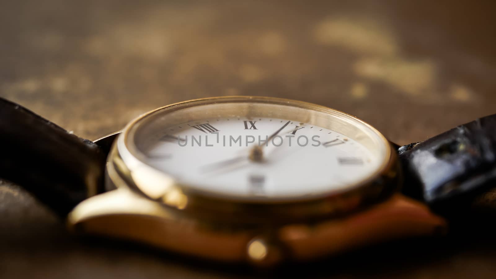 Close up front view of a modern wrist watch on the table. Soft focus