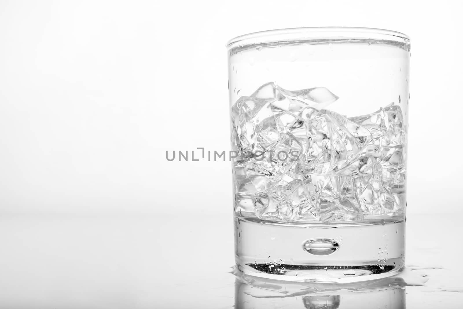 Glass of pure water with ice cubes.
