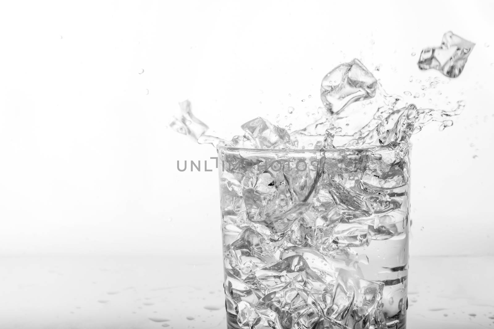Splashing of water with ice in glass