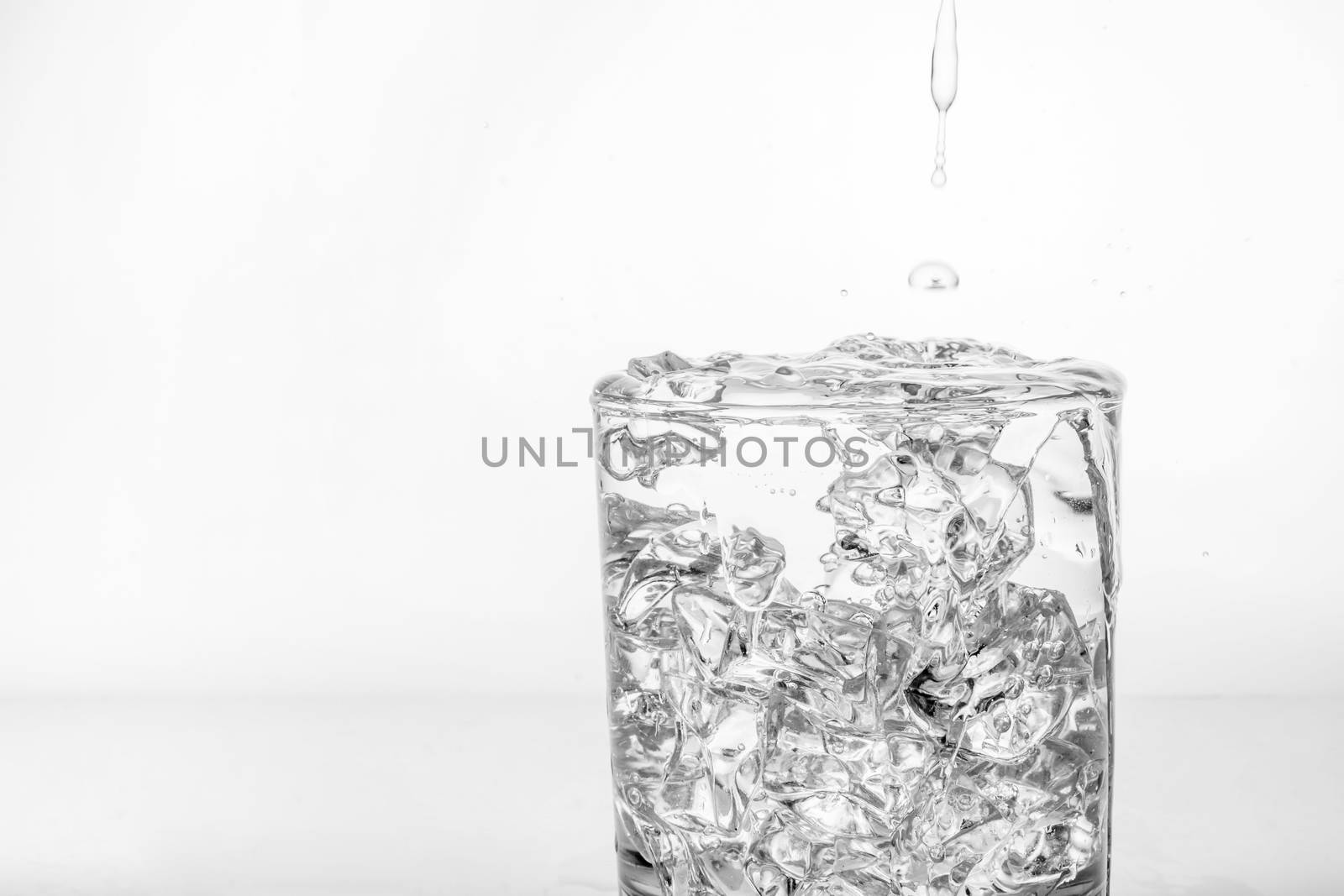 glass with ice and splashing water