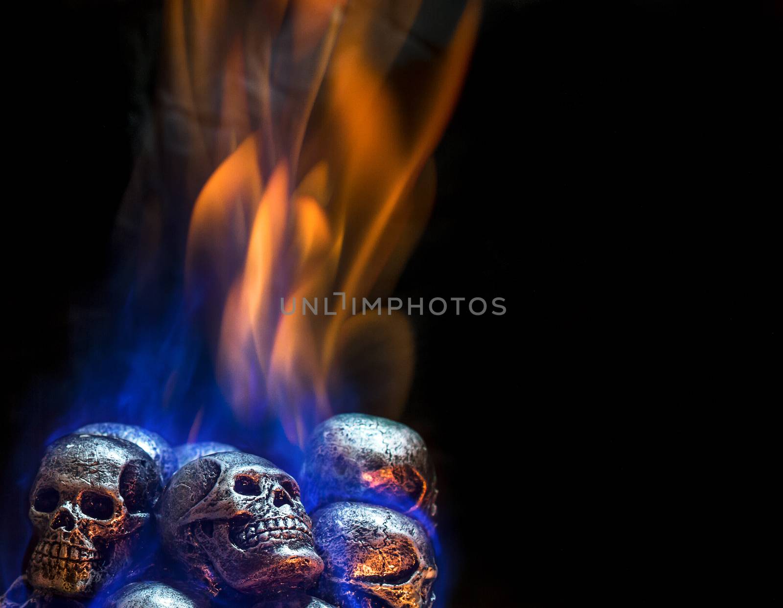 Burning skulls on black background