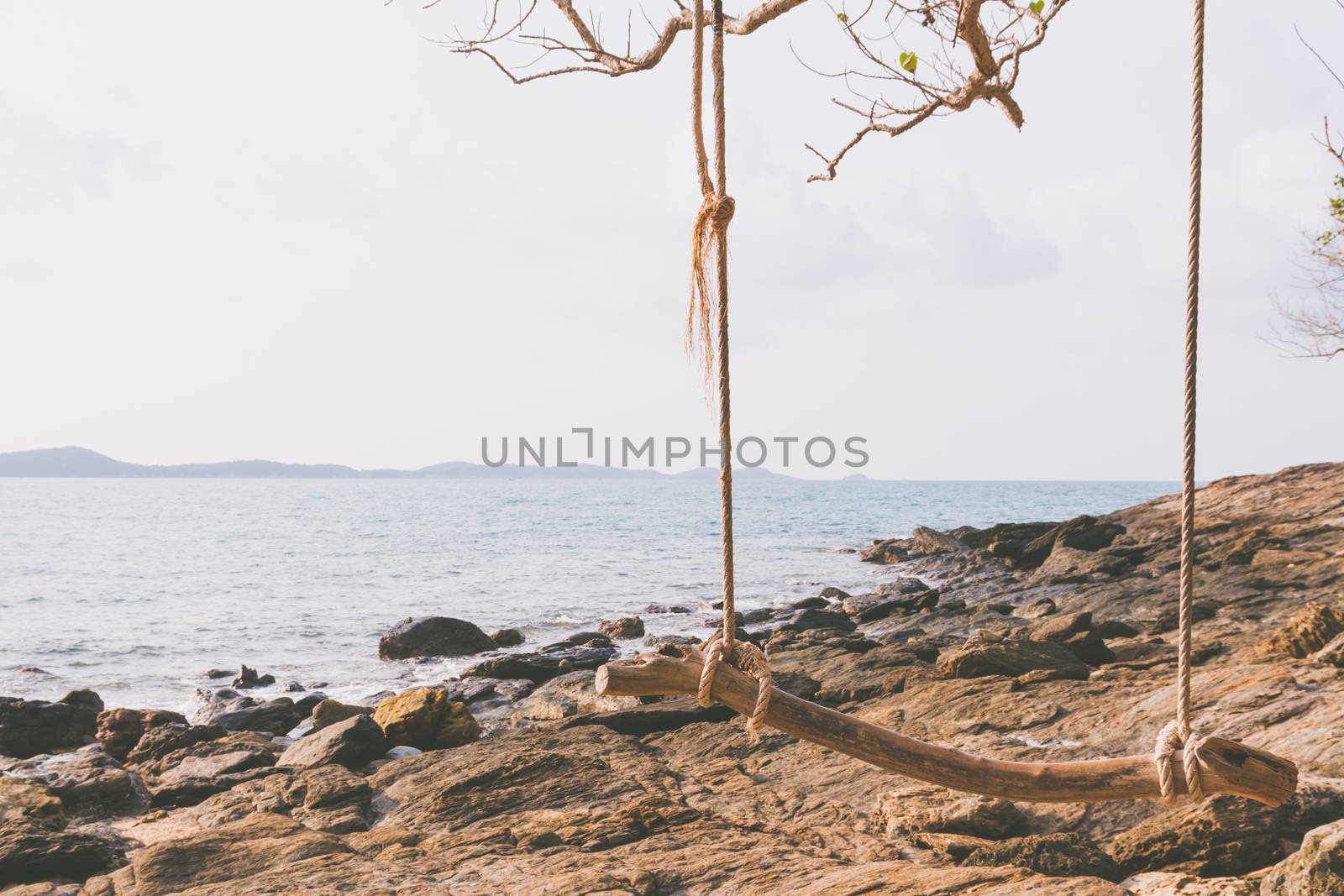 wood swing on the  beach. vintage filter effect