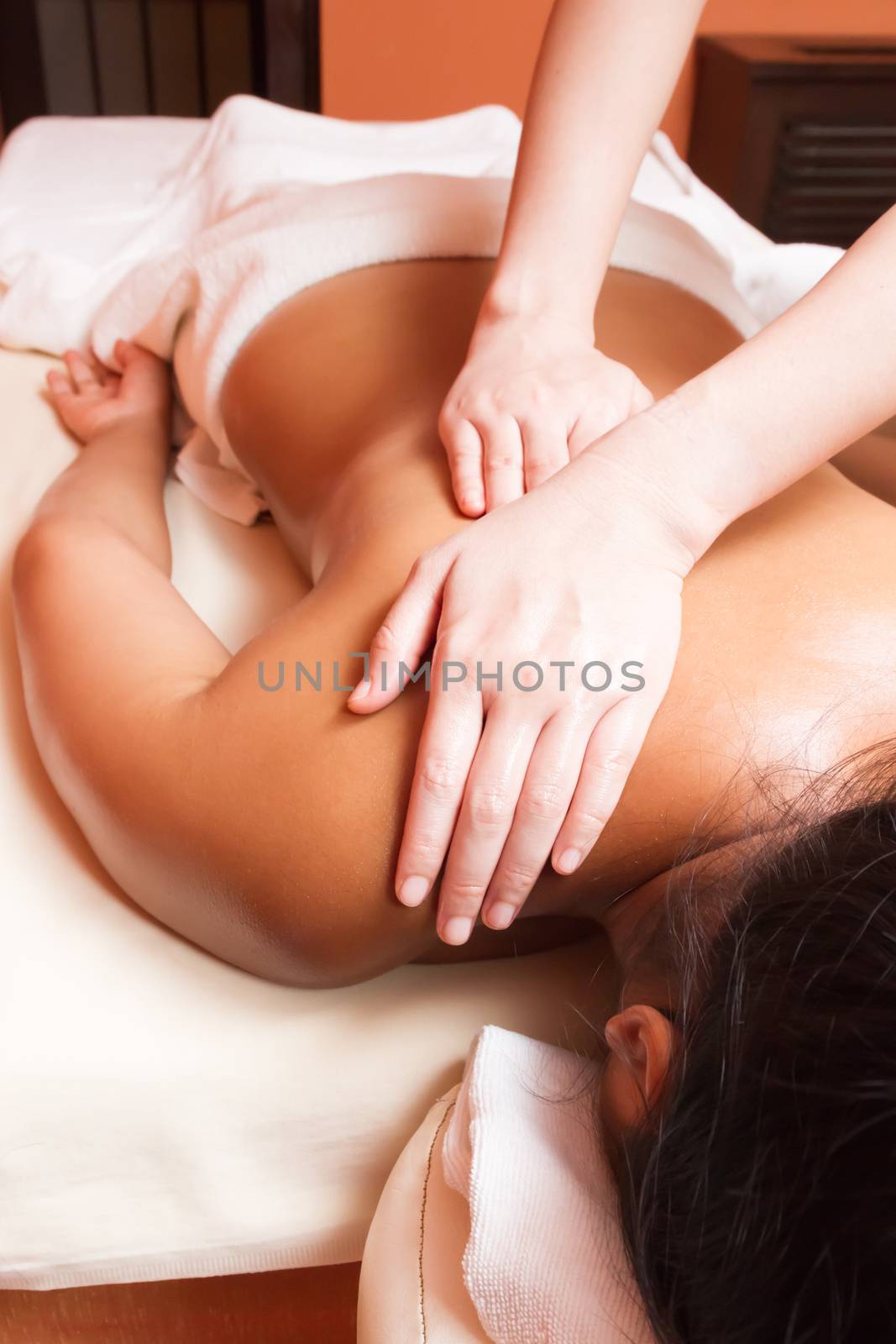 woman getting a massage at a health and beauty spa by ronnarong