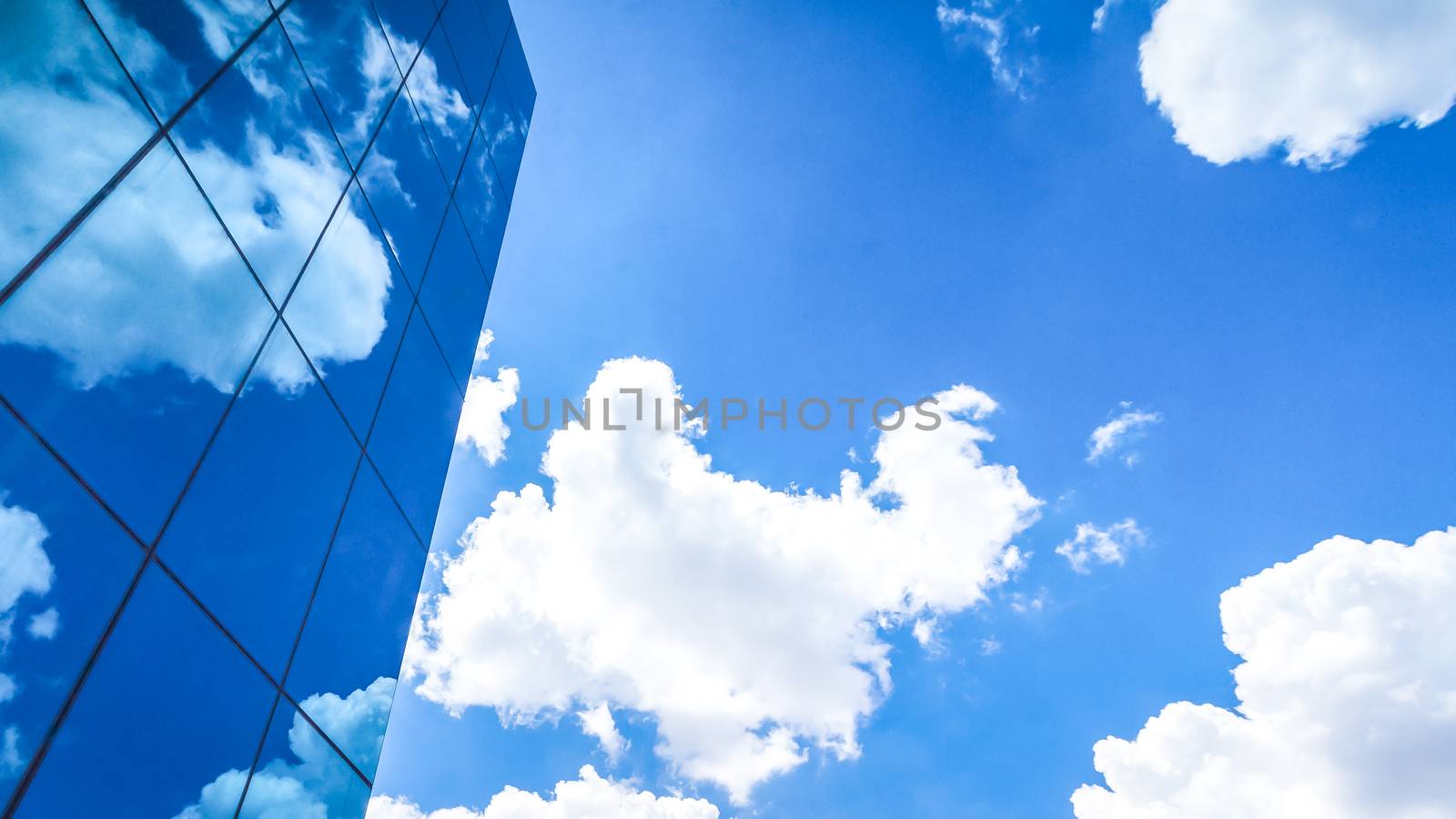 clouds reflected in the many mirrored facets of a modern office building