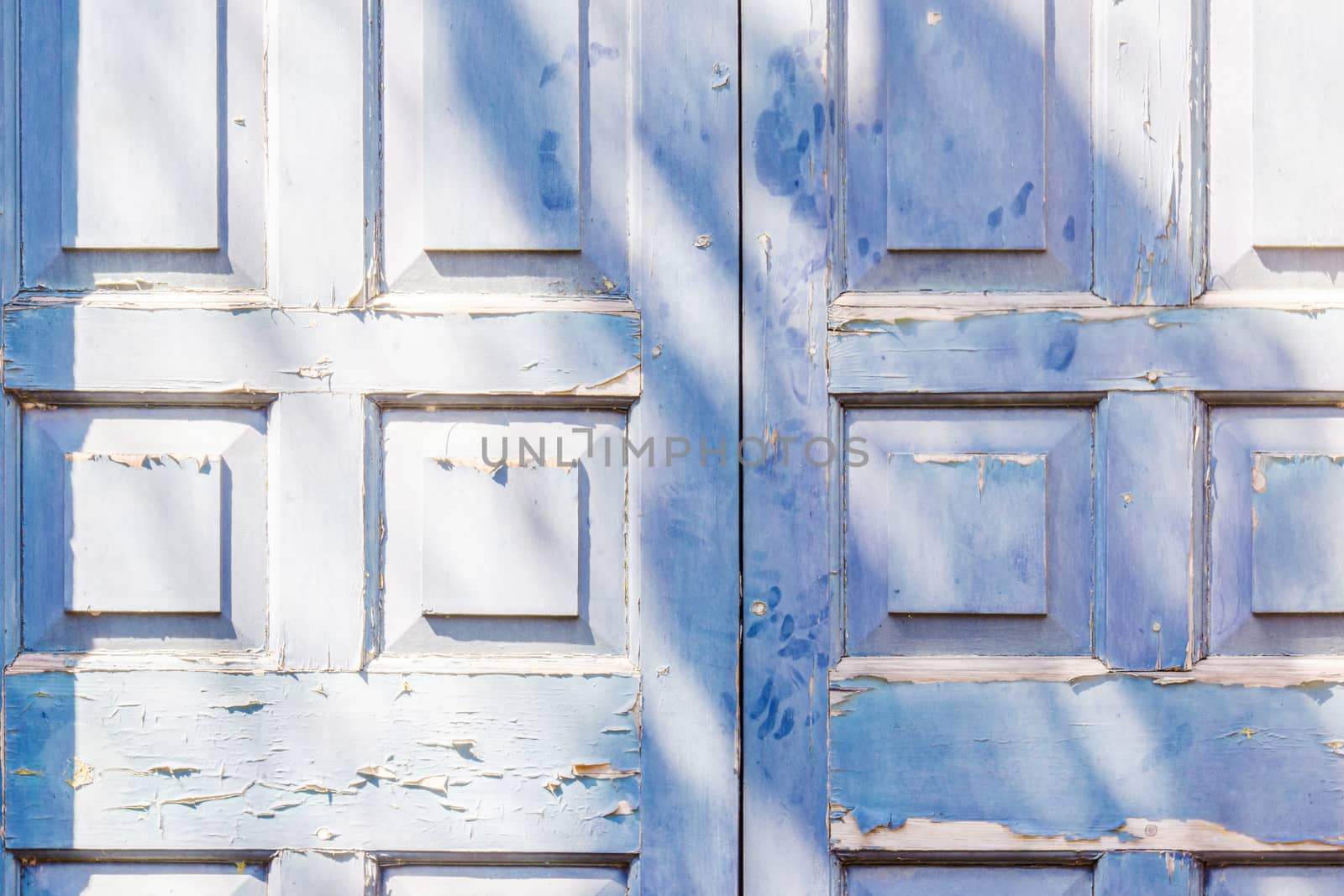 Blue door with squre pattern and peeling paint