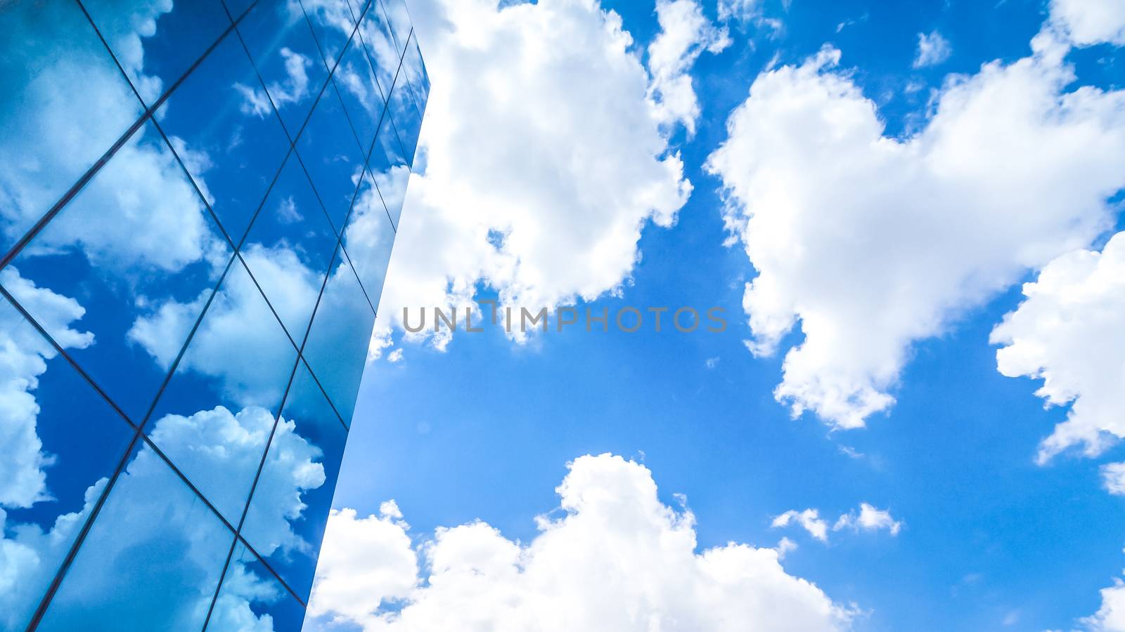 clouds reflected in the many mirrored facets of a modern office building