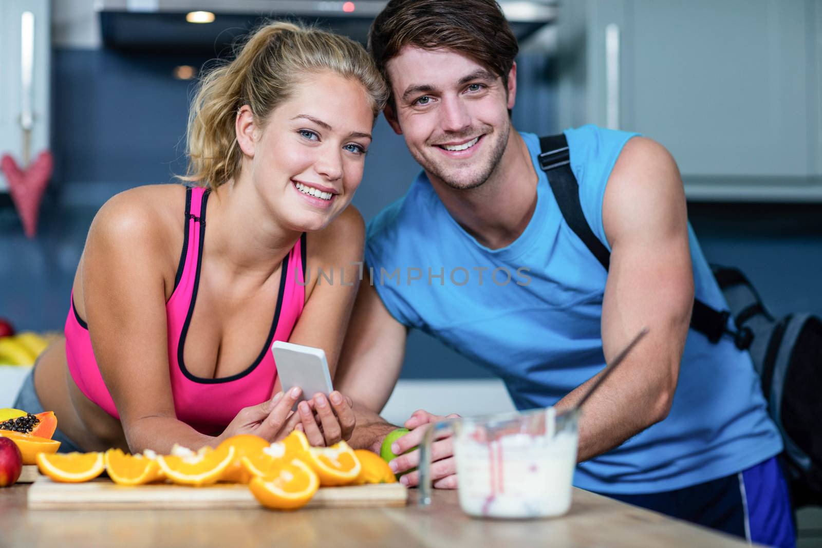 Healthy couple looking at smartphone in the kitchen