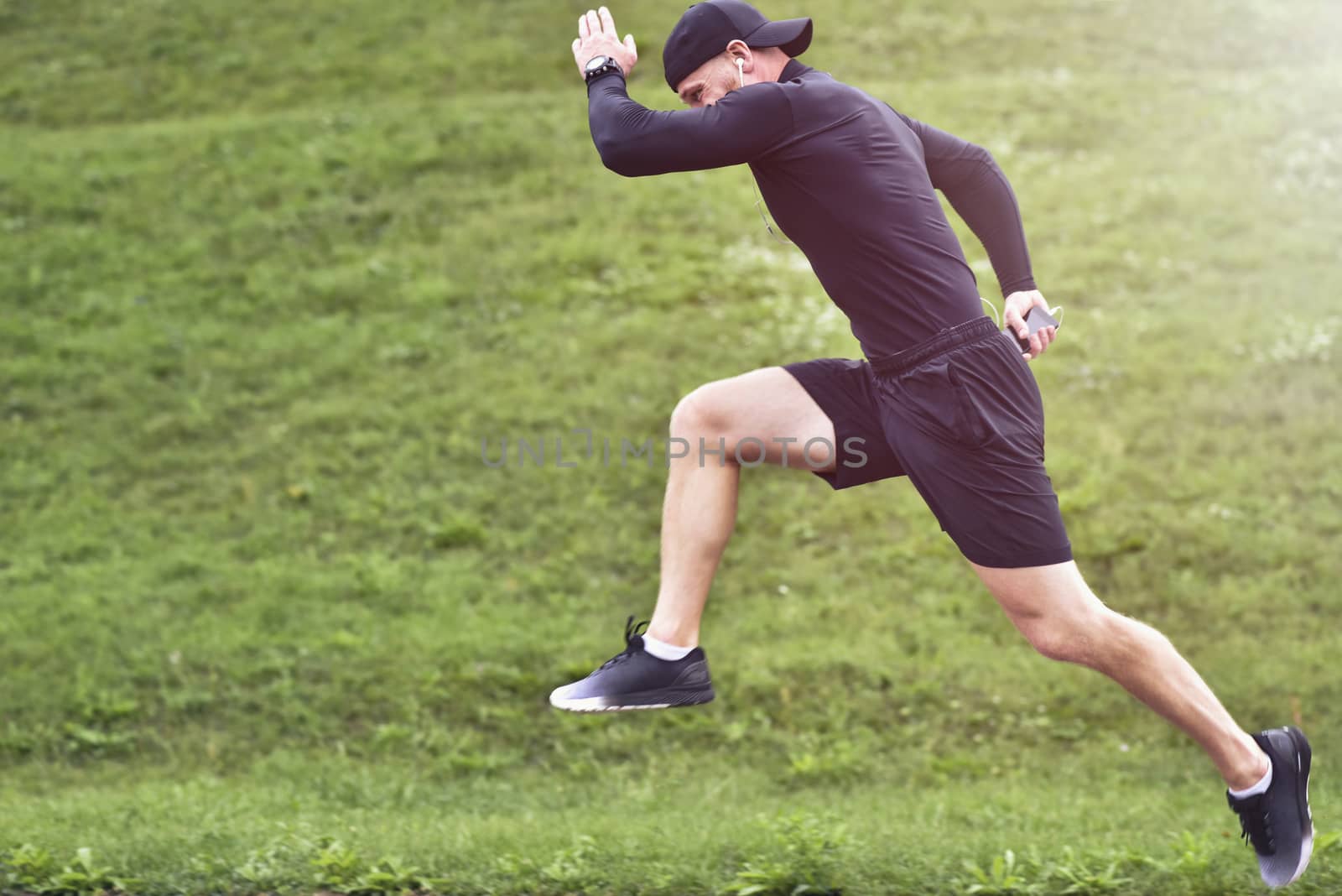 Portrait of concentrated confident muscular full of strength sportsman wearing shorts and sneakers.